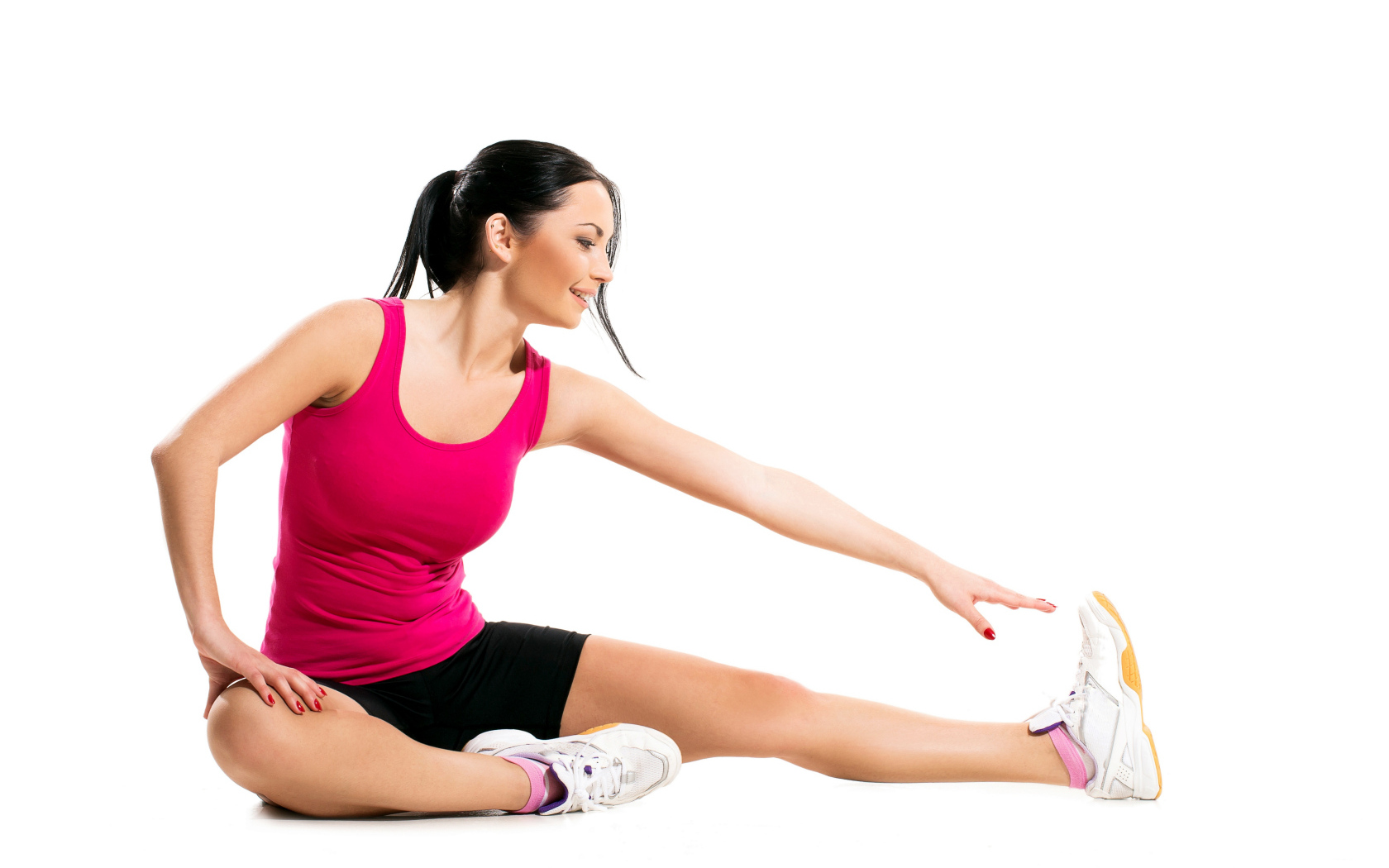 Красивая брюнетка делает упражнения на белом фоне