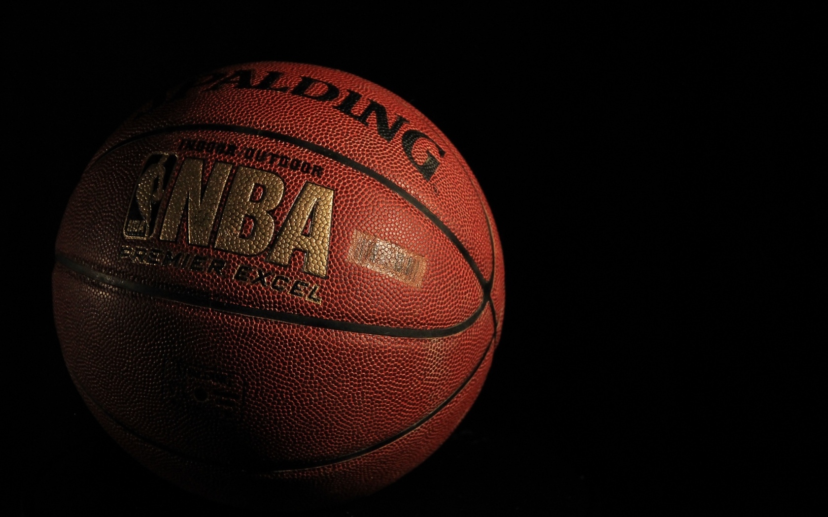 Кожаный баскетбольный мяч на черном фоне
