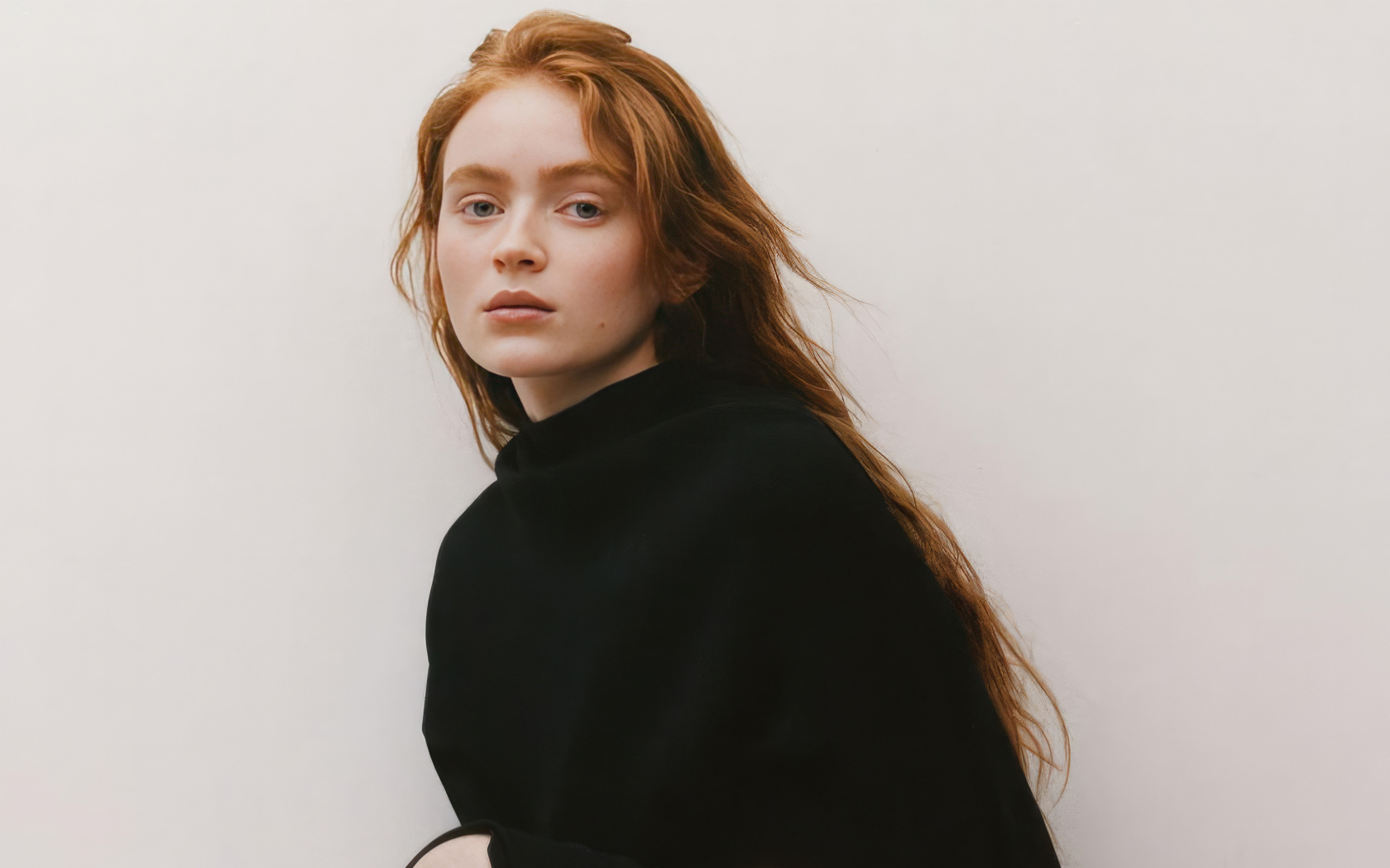 Молодая рыжеволосая актриса Сэди Синк в черном худи