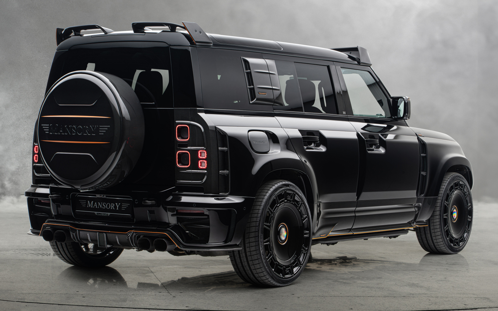 Вид сзади на черный автомобиль Mansory Land Rover Defender 110 Black Edition 2024 года