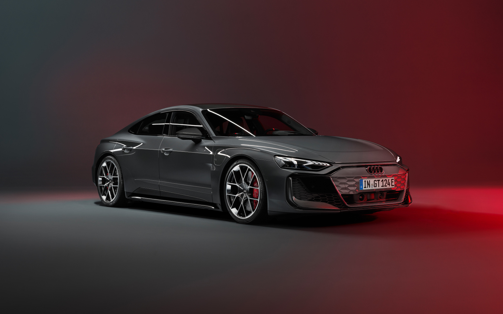 Автомобиль Audi RS e-tron GT 2024 года на красном фоне