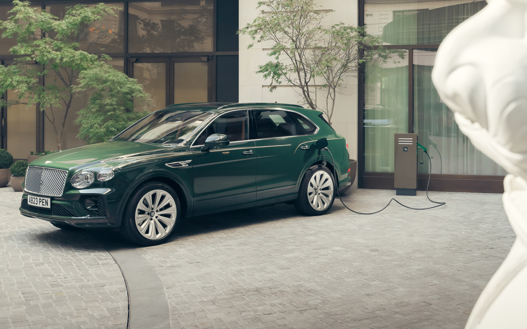 Зеленый автомобиль Bentley Bentayga Hybrid Peninsula London 2024 года