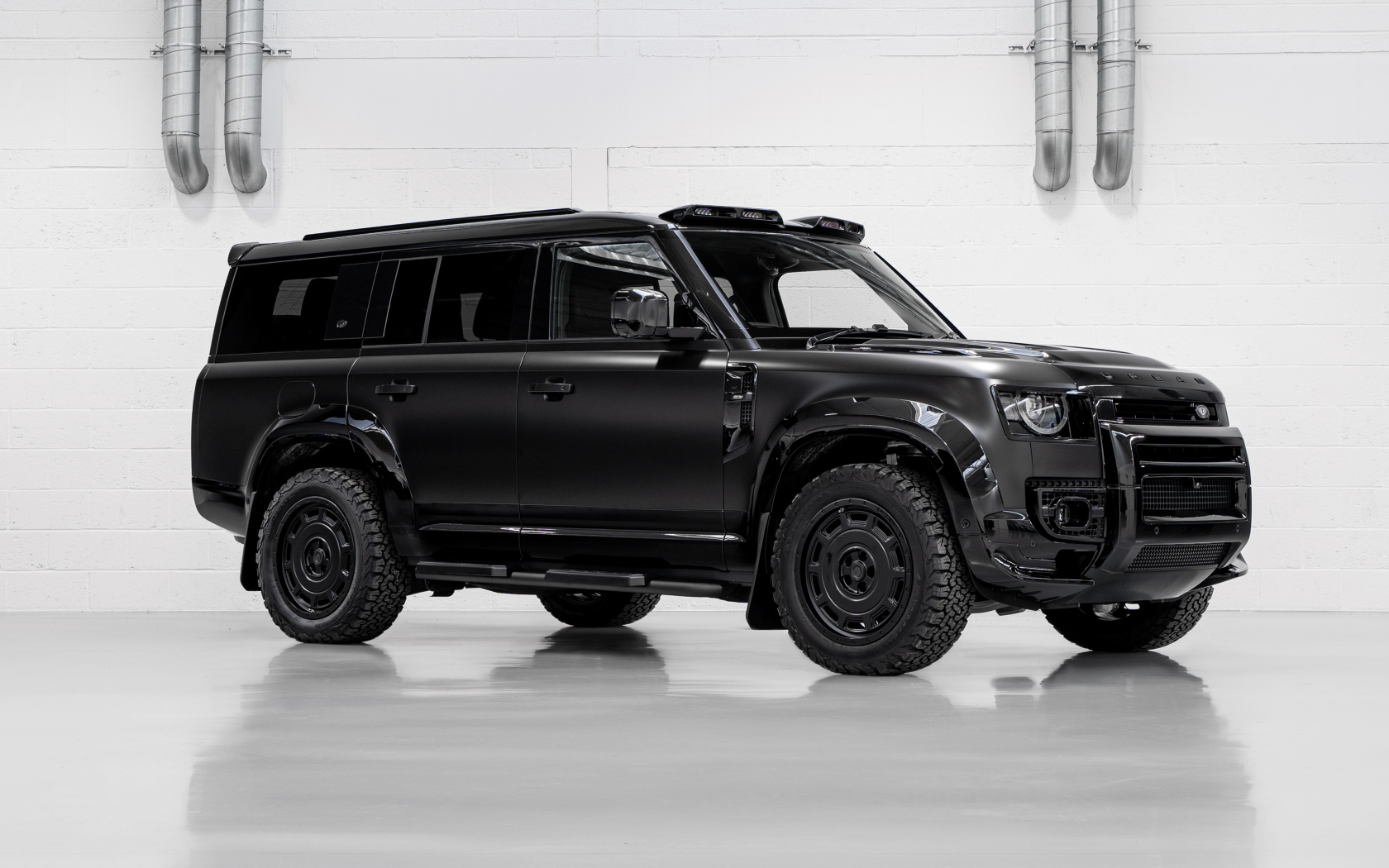 Большой черный автомобиль Land Rover Defender Widetrack 2024 года