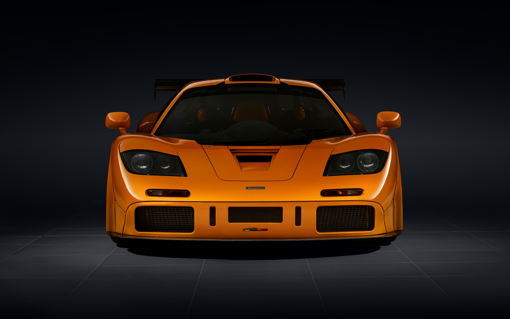 Вид спереди на оранжевый автомобиль McLaren F1 LM