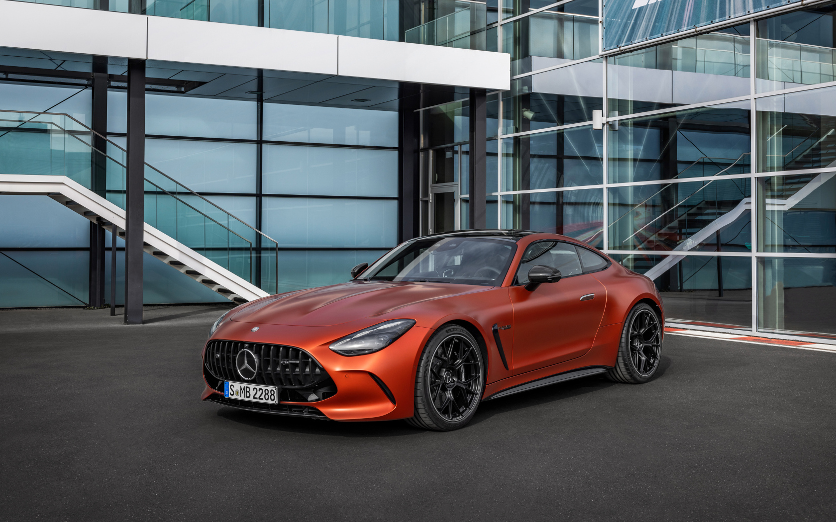 Красный автомобиль Mercedes-AMG GT 63 S E Performance 2024 года у здания