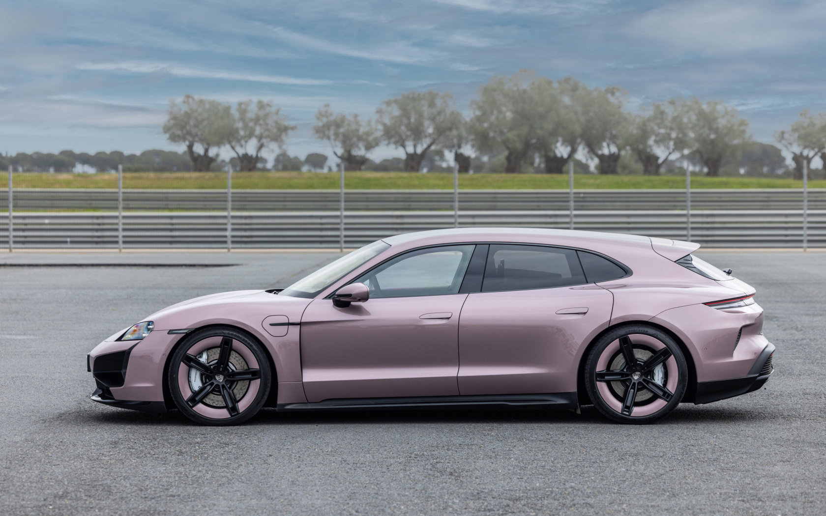 Вид сбоку на автомобиль Porsche Taycan Turbo Sport Turismo 2024 года