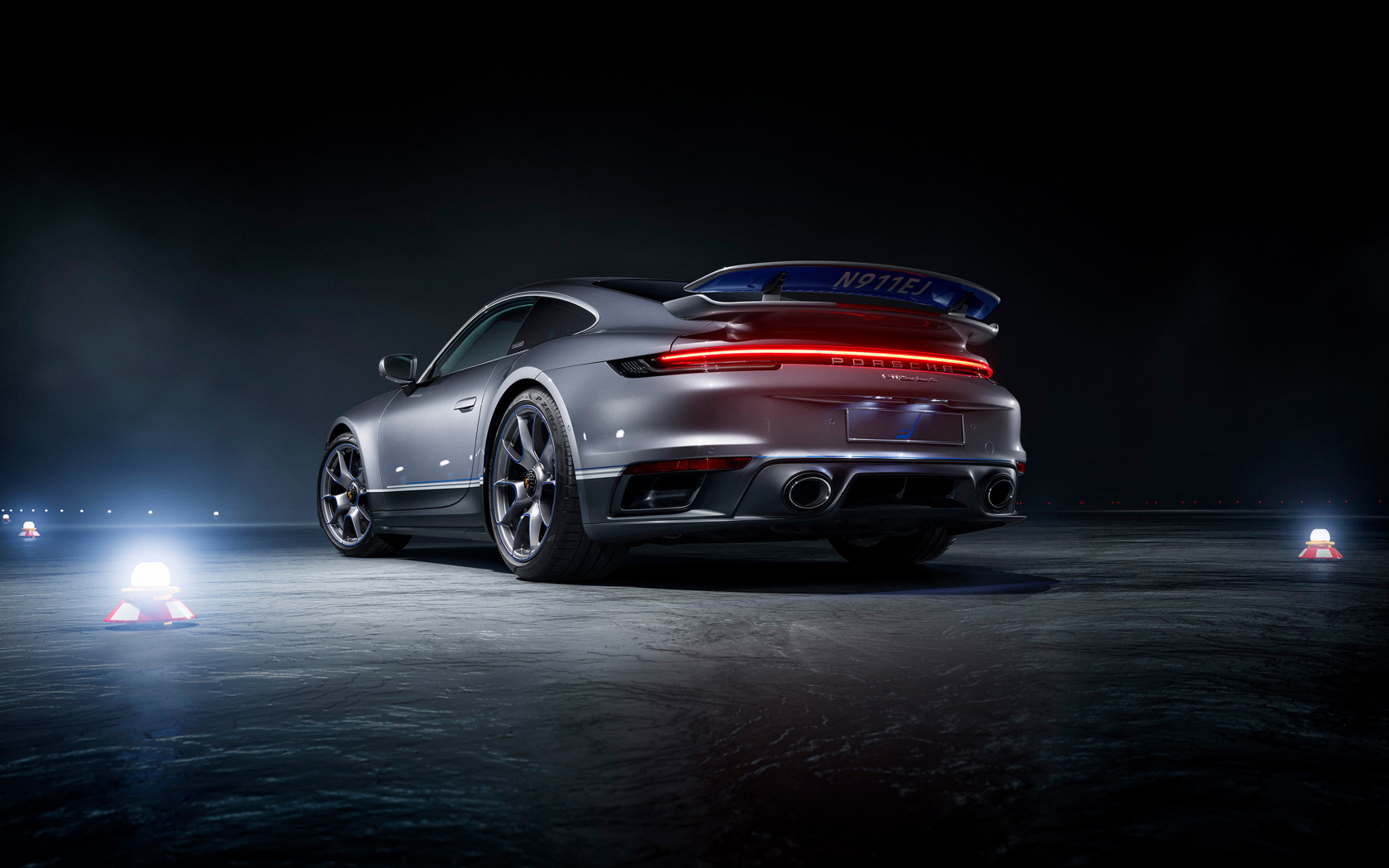 Серебристый автомобиль Porsche 911 Turbo S вид сзади