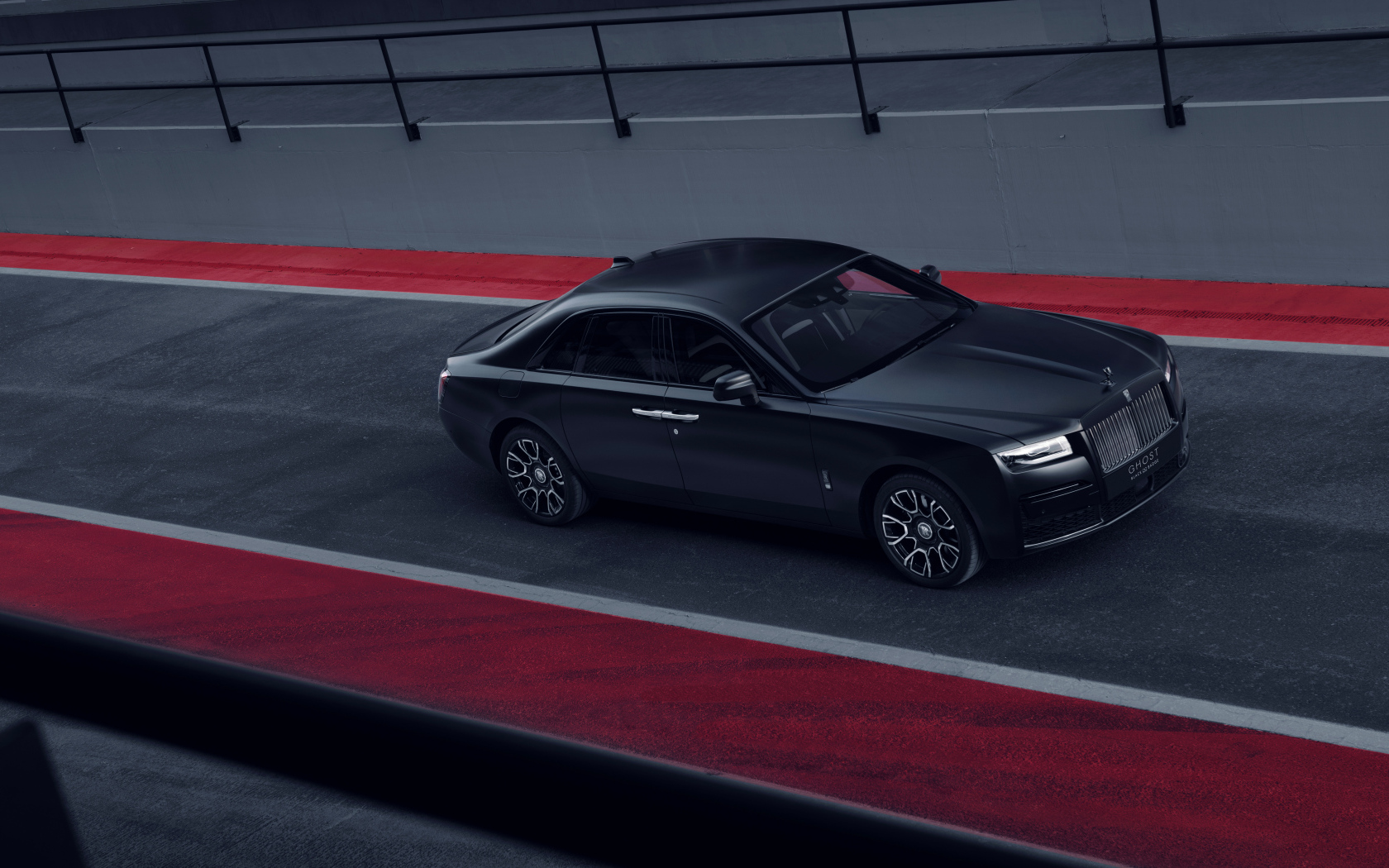 Черный автомобиль Rolls-Royce Black Badge Ghost на дороге