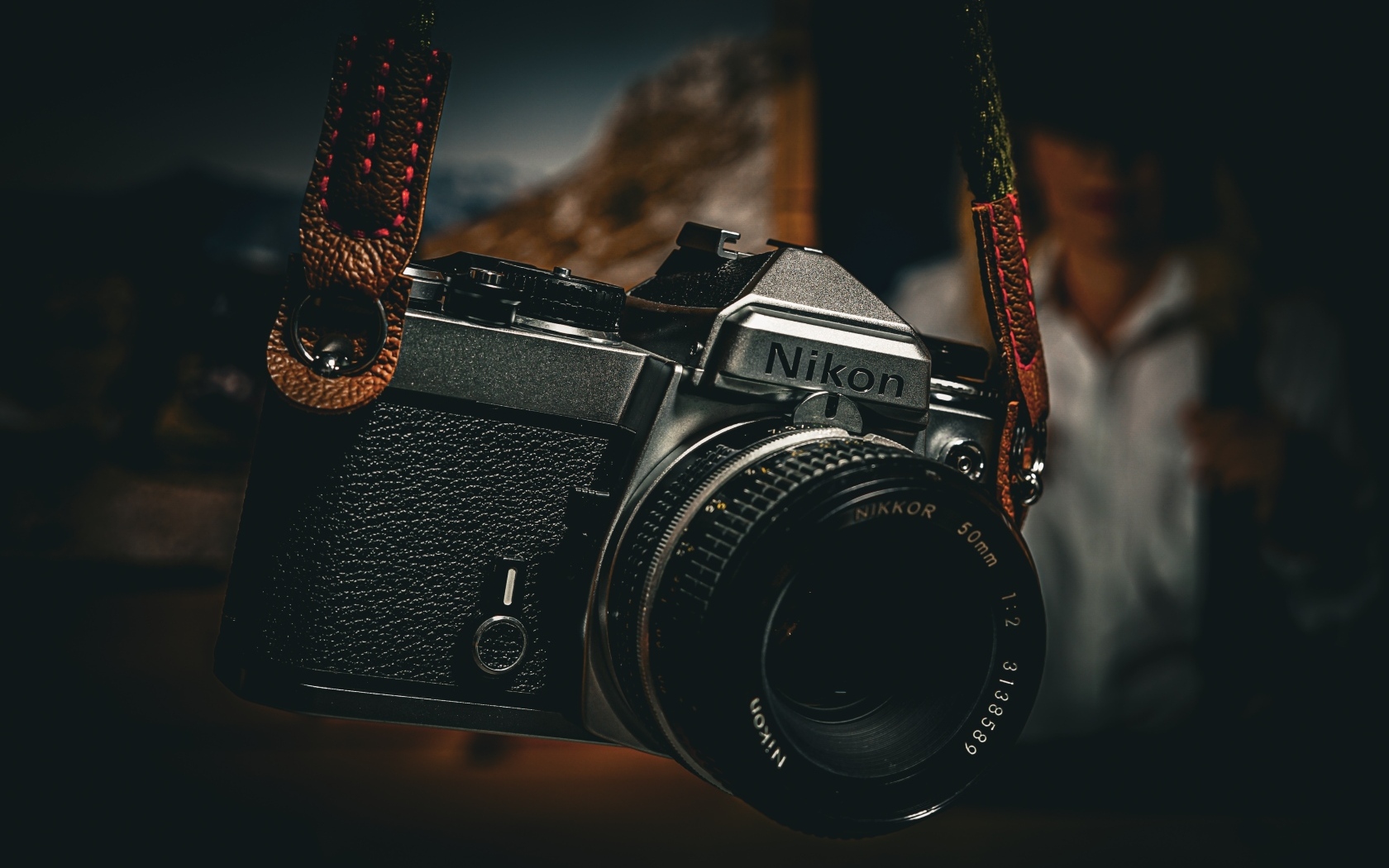 Черный фотоаппарат nikon на ремне