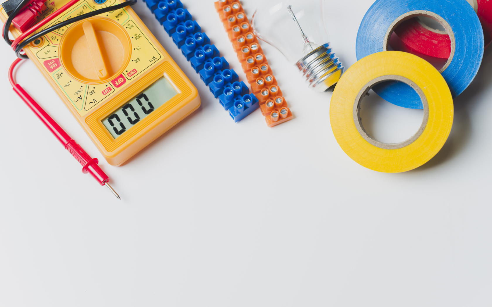 Электрическические приборы, мультиметр, изолента на сером фоне