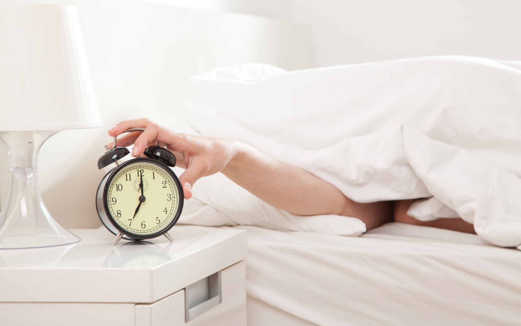 Рука под одеялом отключает будильник