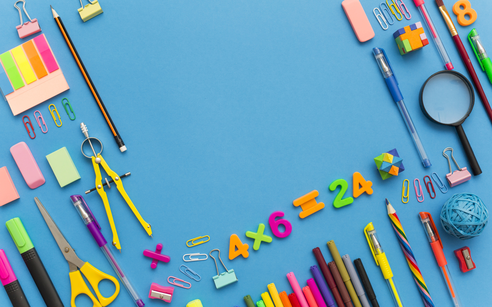 Много разных канцелярских предметов на голубом столе