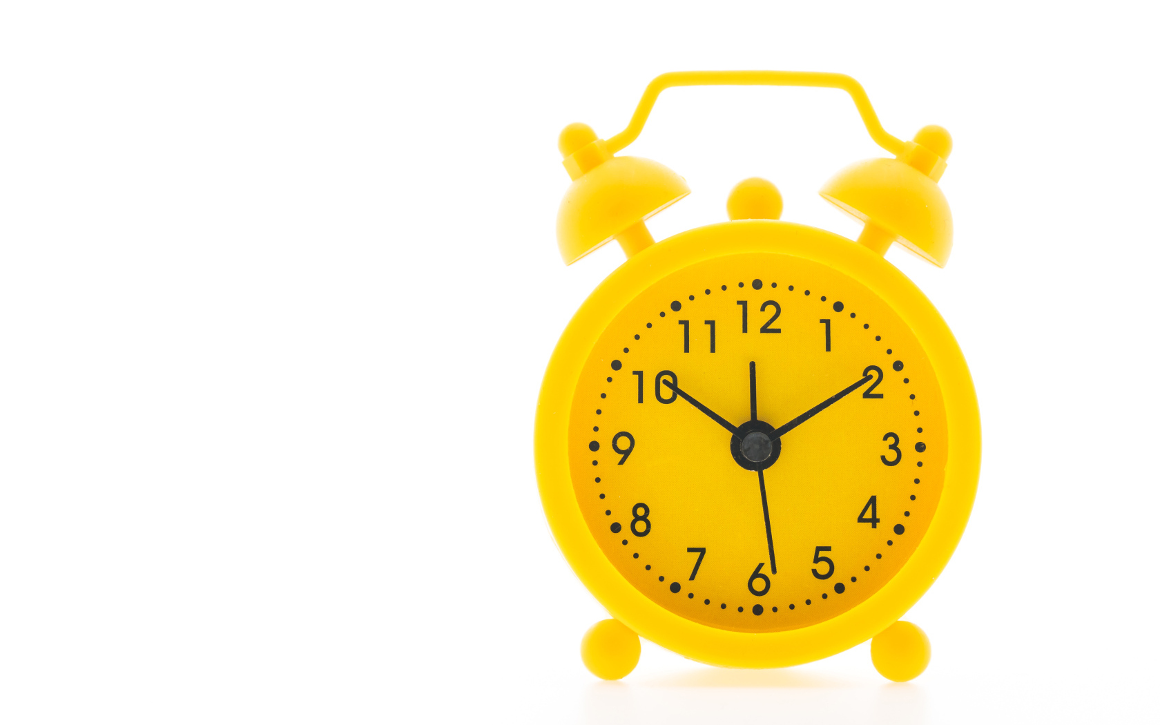 Желтый будильник на белом фоне