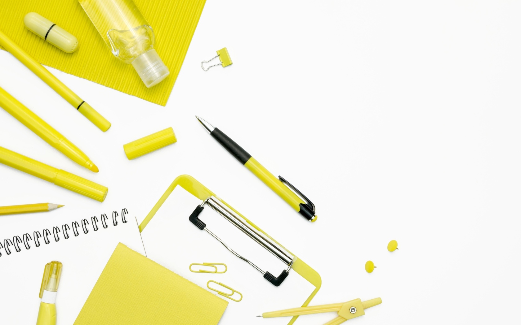 Желтые канцелярские предметы на белом фоне