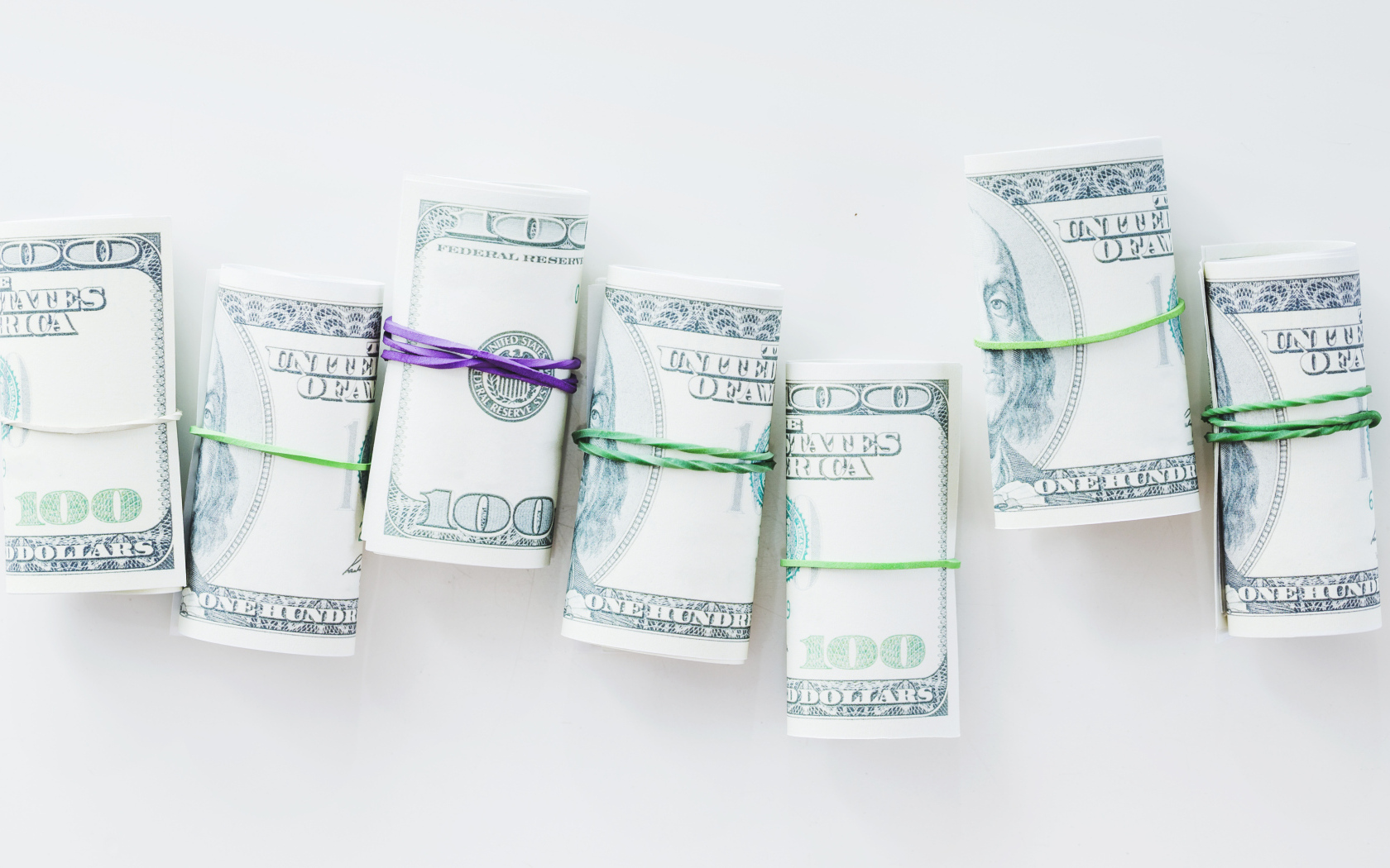 Свертки с долларами на сером фоне