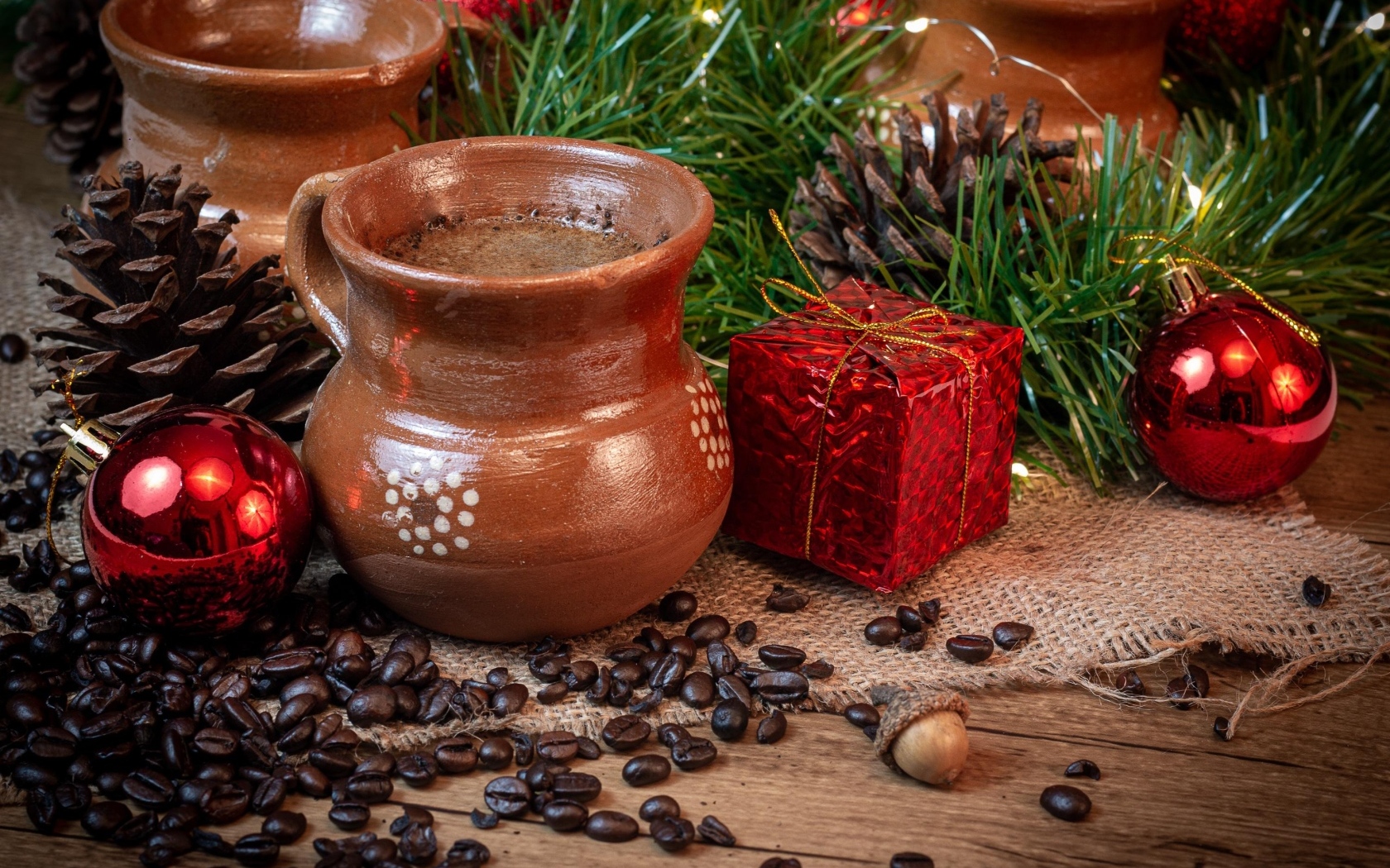 Кофейные зерна на столе с посудой и еловой веткой
