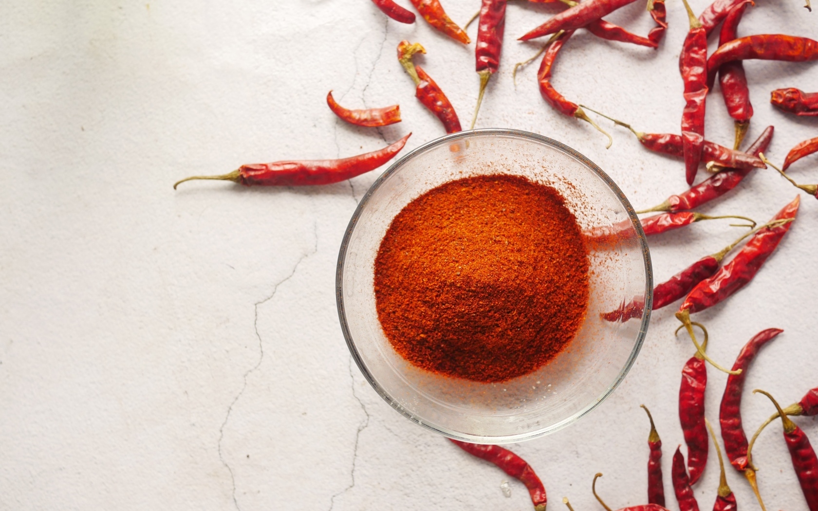 Молотый жгучий красный перец на столе