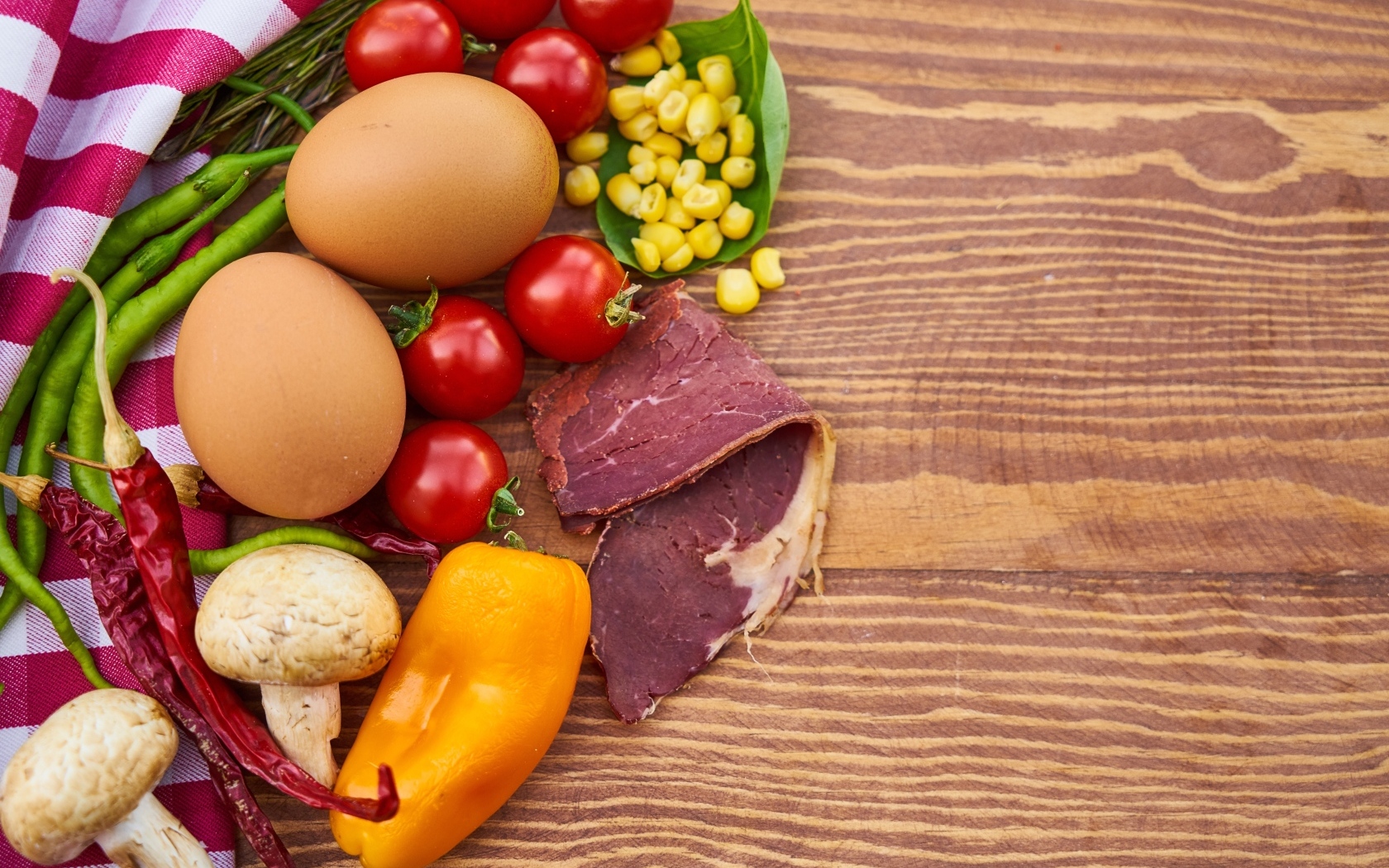 Продукты на деревянном столе с полотенцем