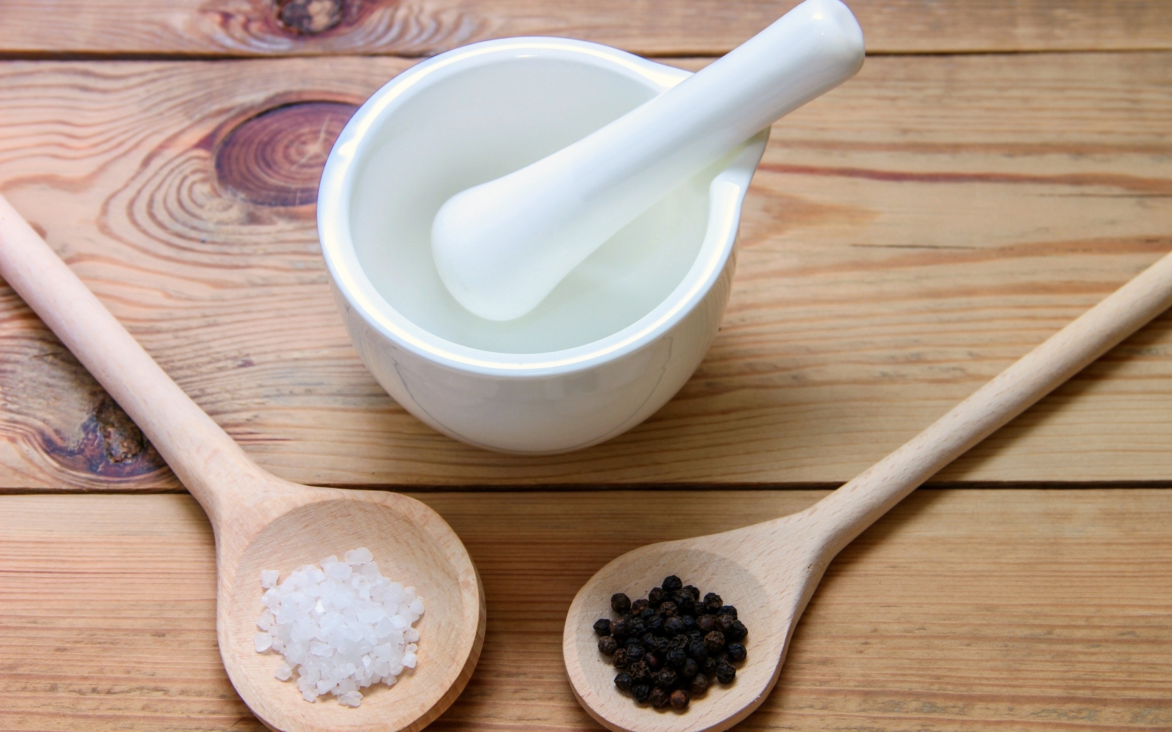 Соль с перцем на столе с деревянной ступкой