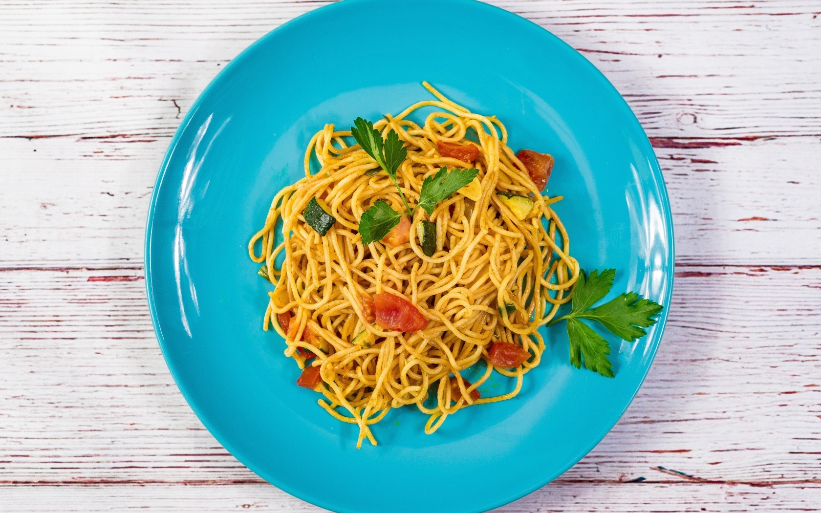 Спагетти с овощами  на голубой тарелке