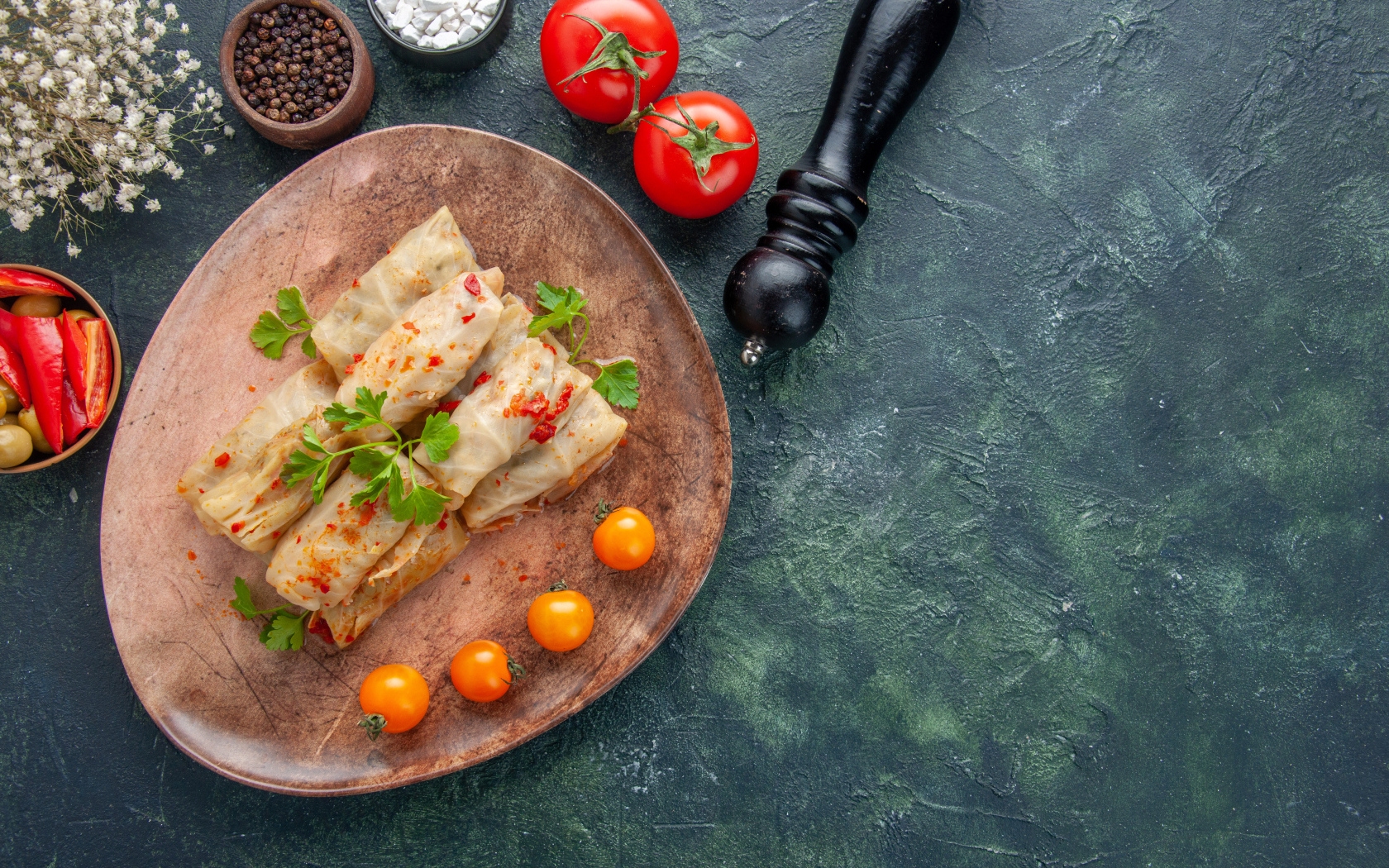 Голубцы на столе с помидорами и специями