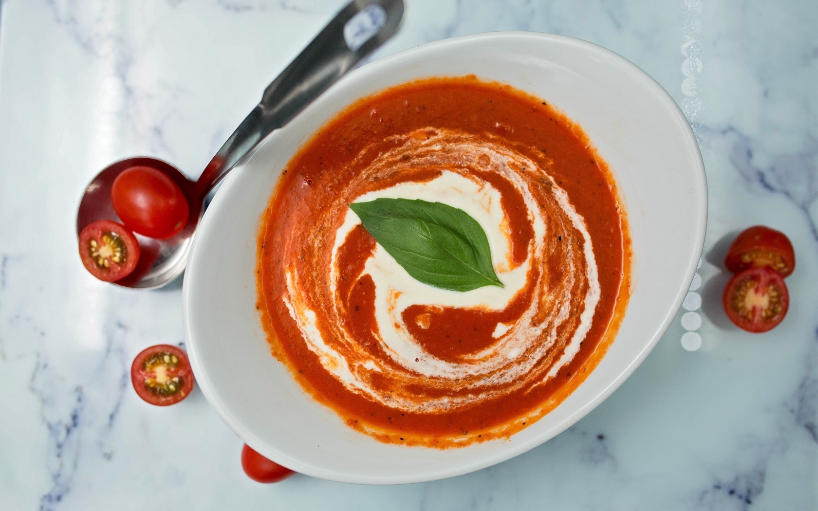 Томатный суп со сметаной в белой тарелке
