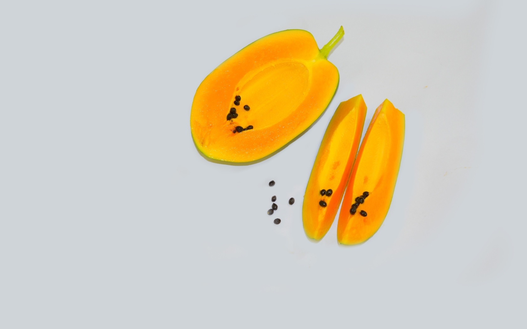Разрезанная папайя на сером фоне