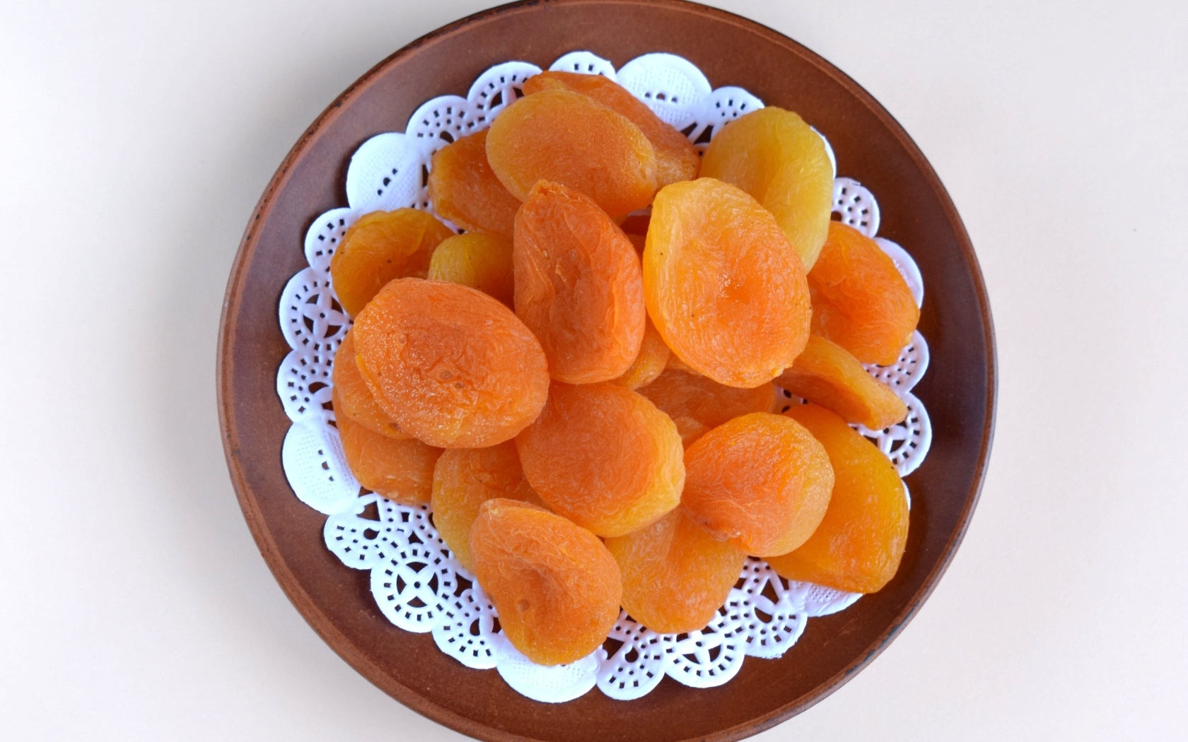 Курага с тарелке на сером фоне