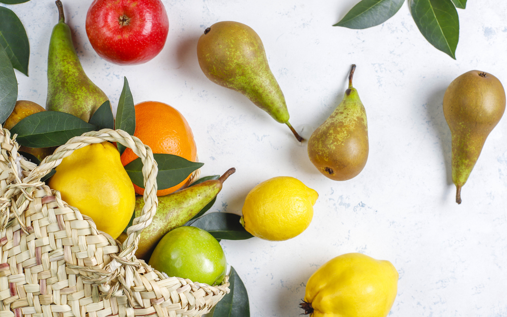 Груши, яблоки и апельсины с сумкой на столе