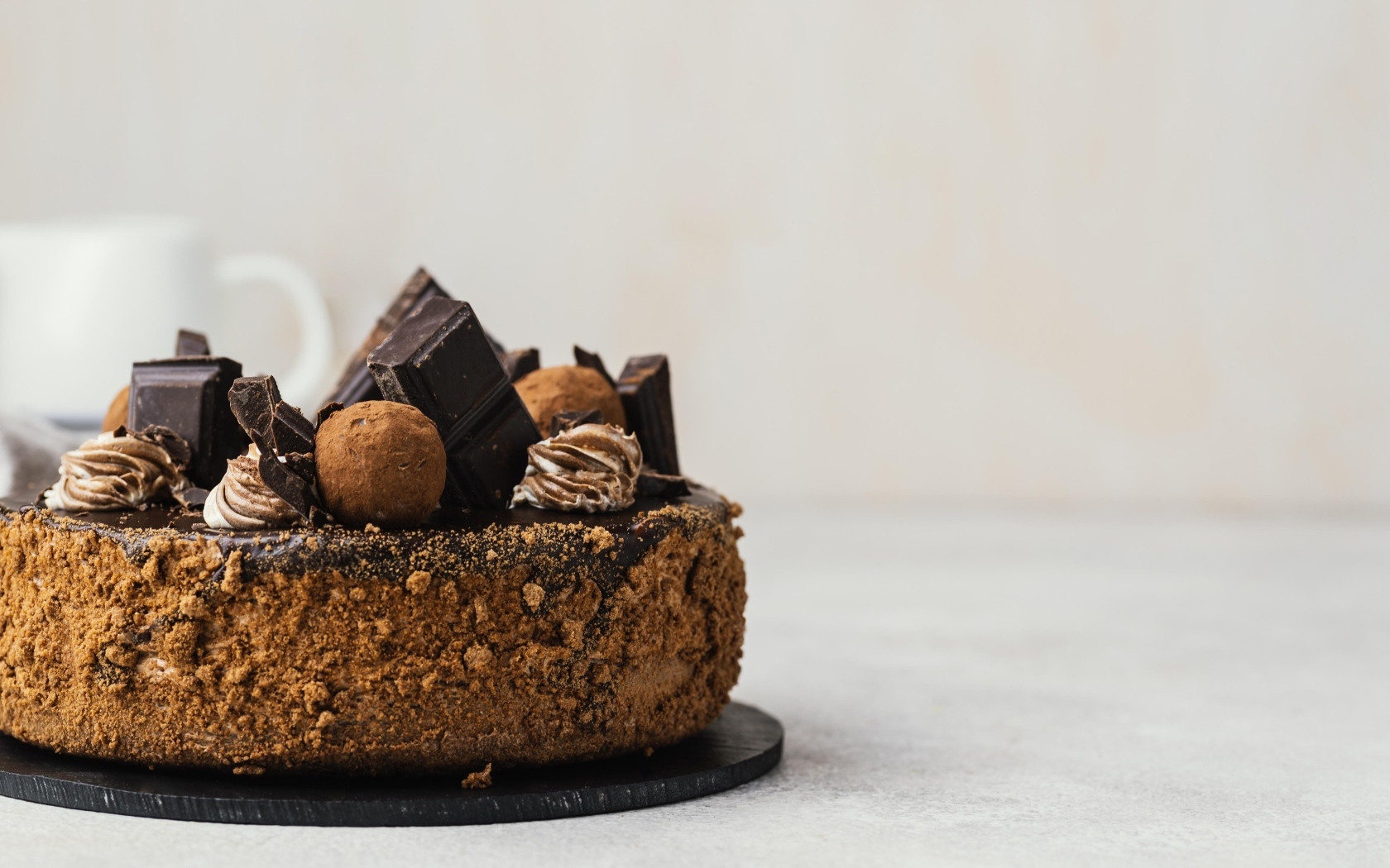 Торт украшен шоколадной глазурью и конфетами на сером фоне