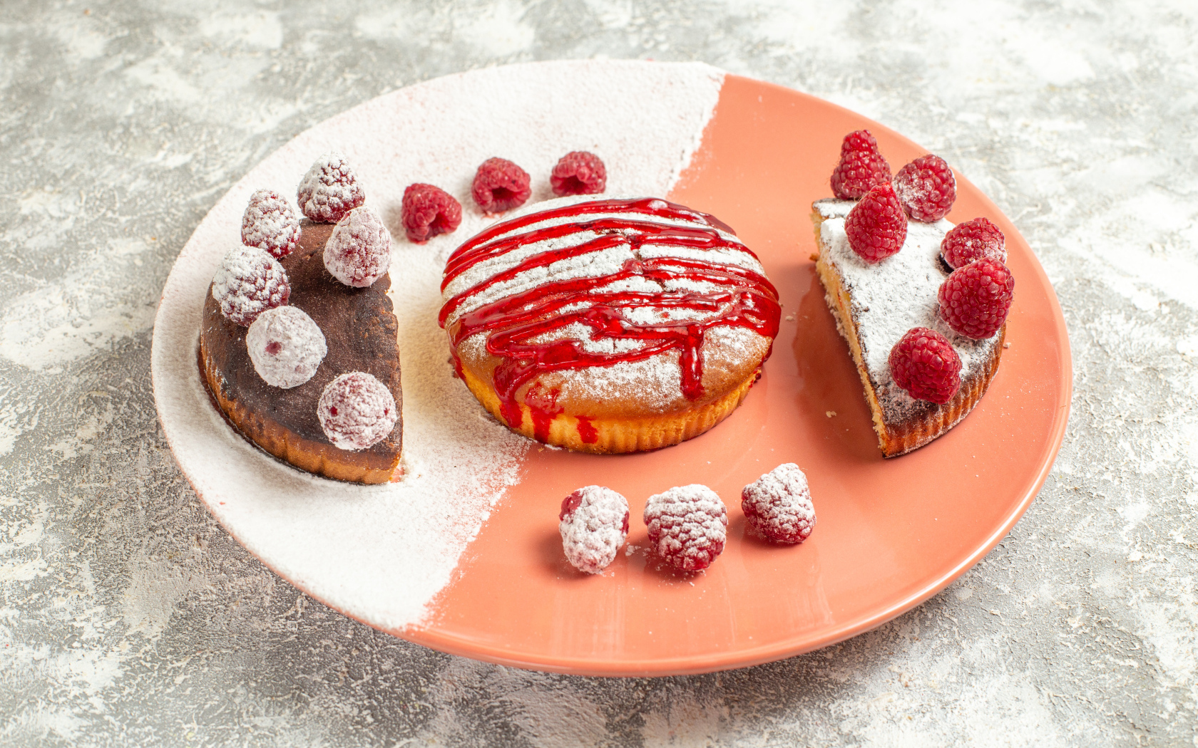 Десерт с ягодами малины и сахарной пудрой на большой тарелке