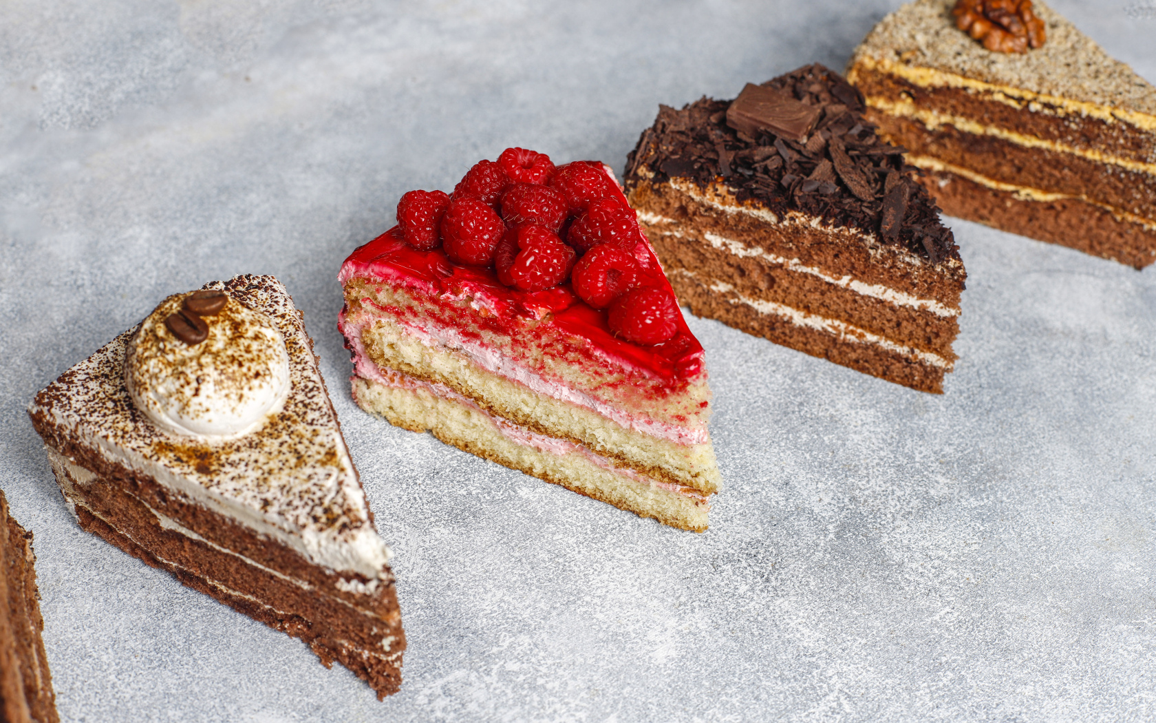 Четыре разных вкусных куска торта на столе