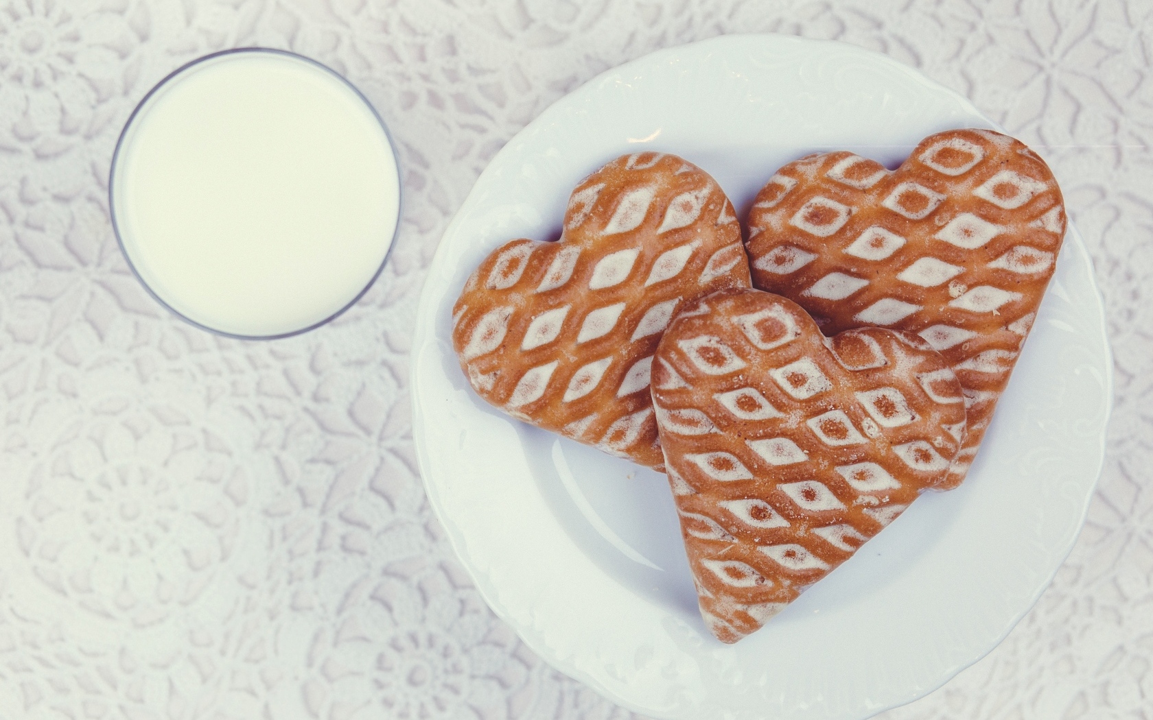 Печенье в форме сердца на столе с молоком