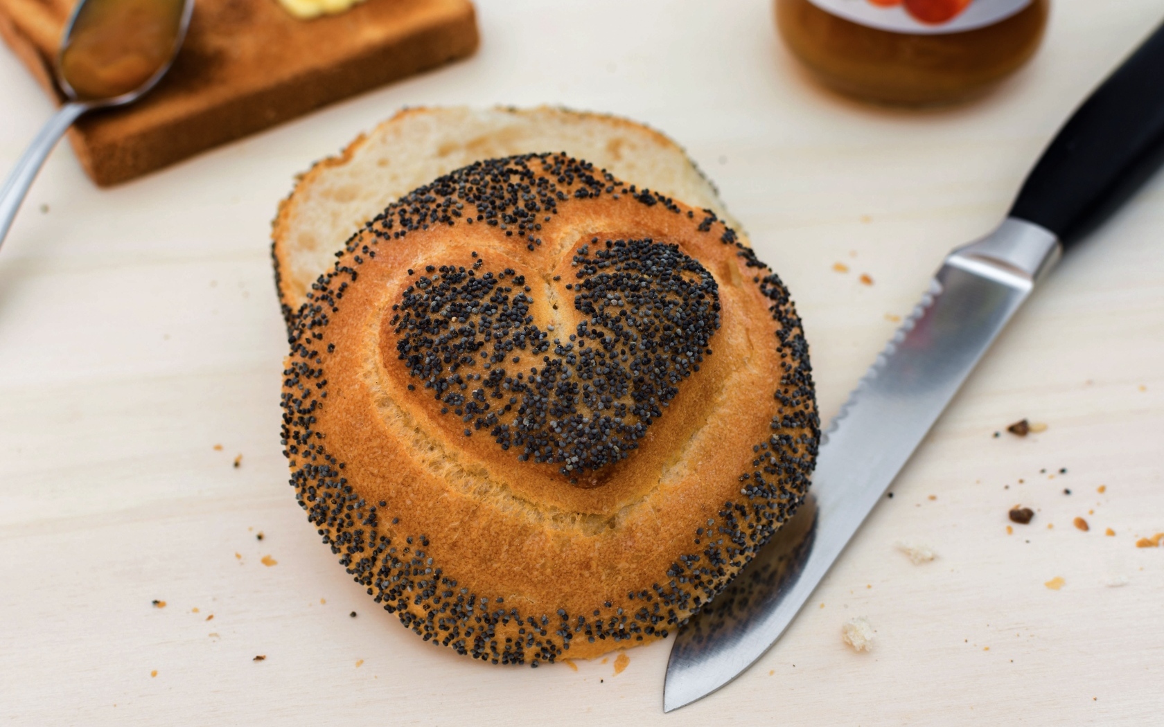 Булочка с маком с нарисованным сердцем на столе