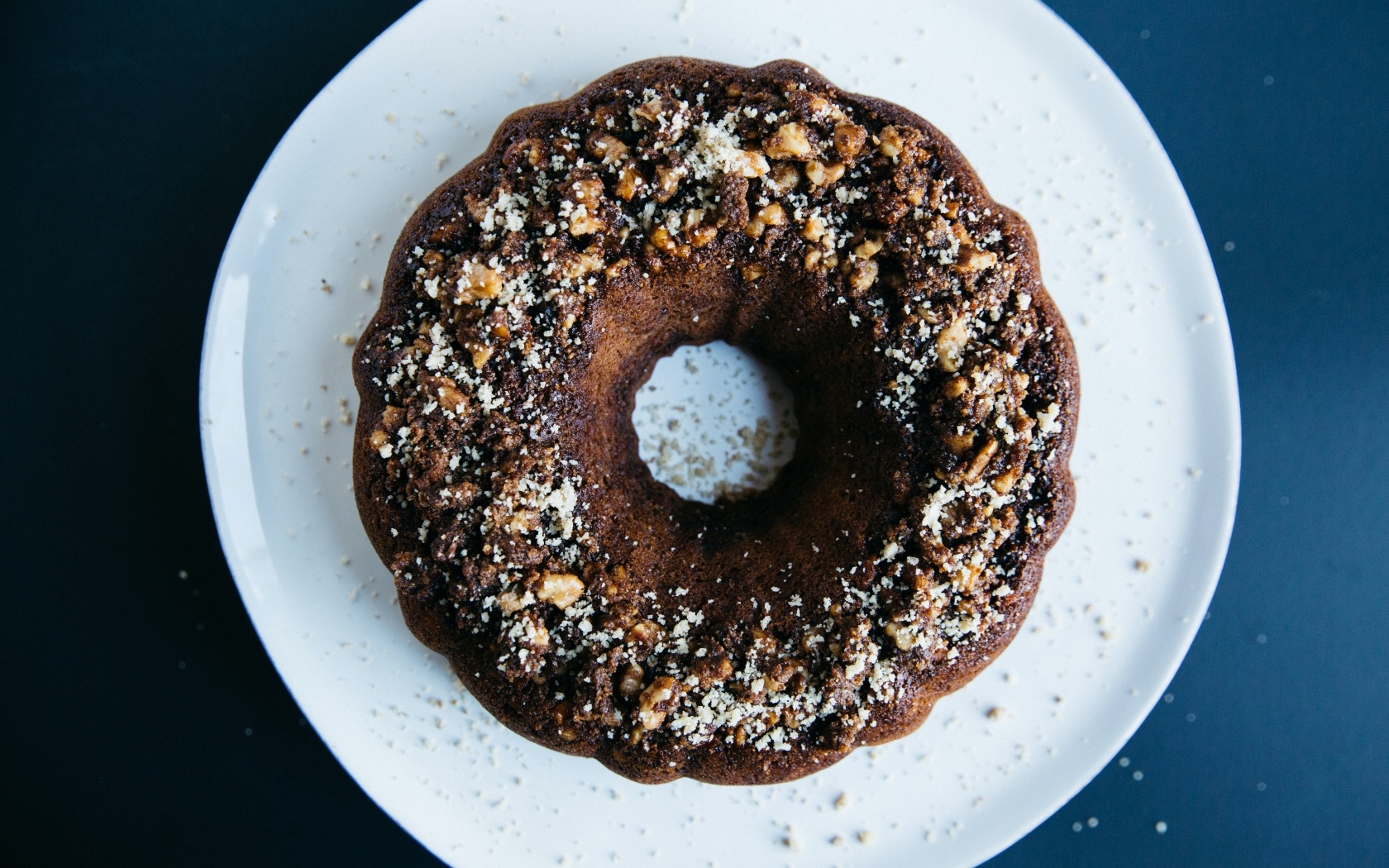 Круглый шоколадный кекс на большой белой тарелке