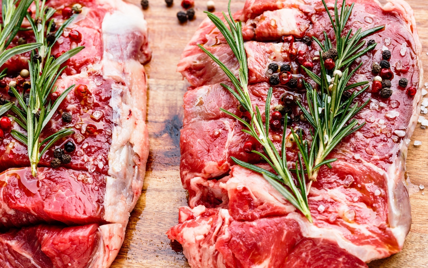 Кусок свежего мяса с перцем и розмарином