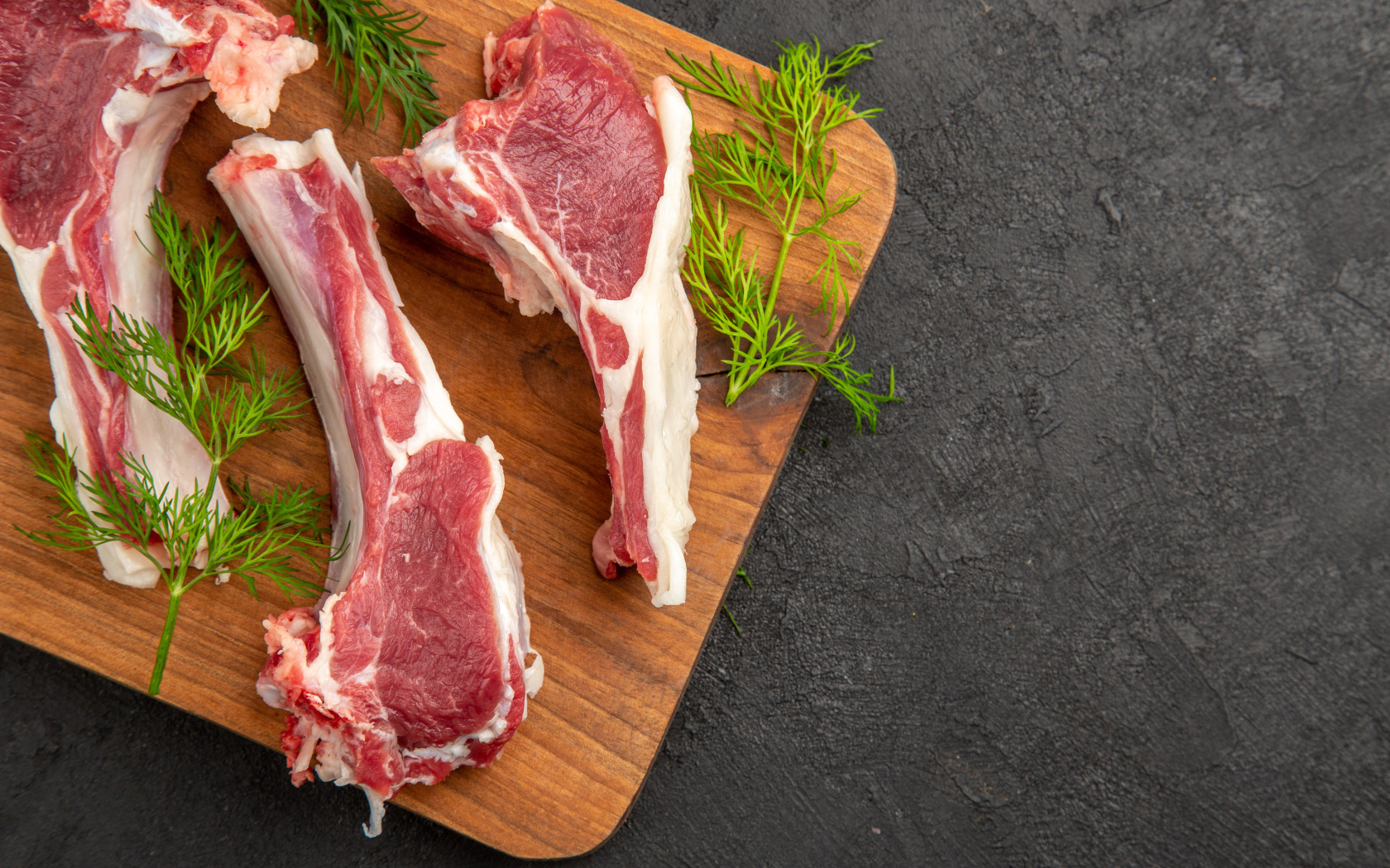 Свиные ребра на разделочной доске с укропом
