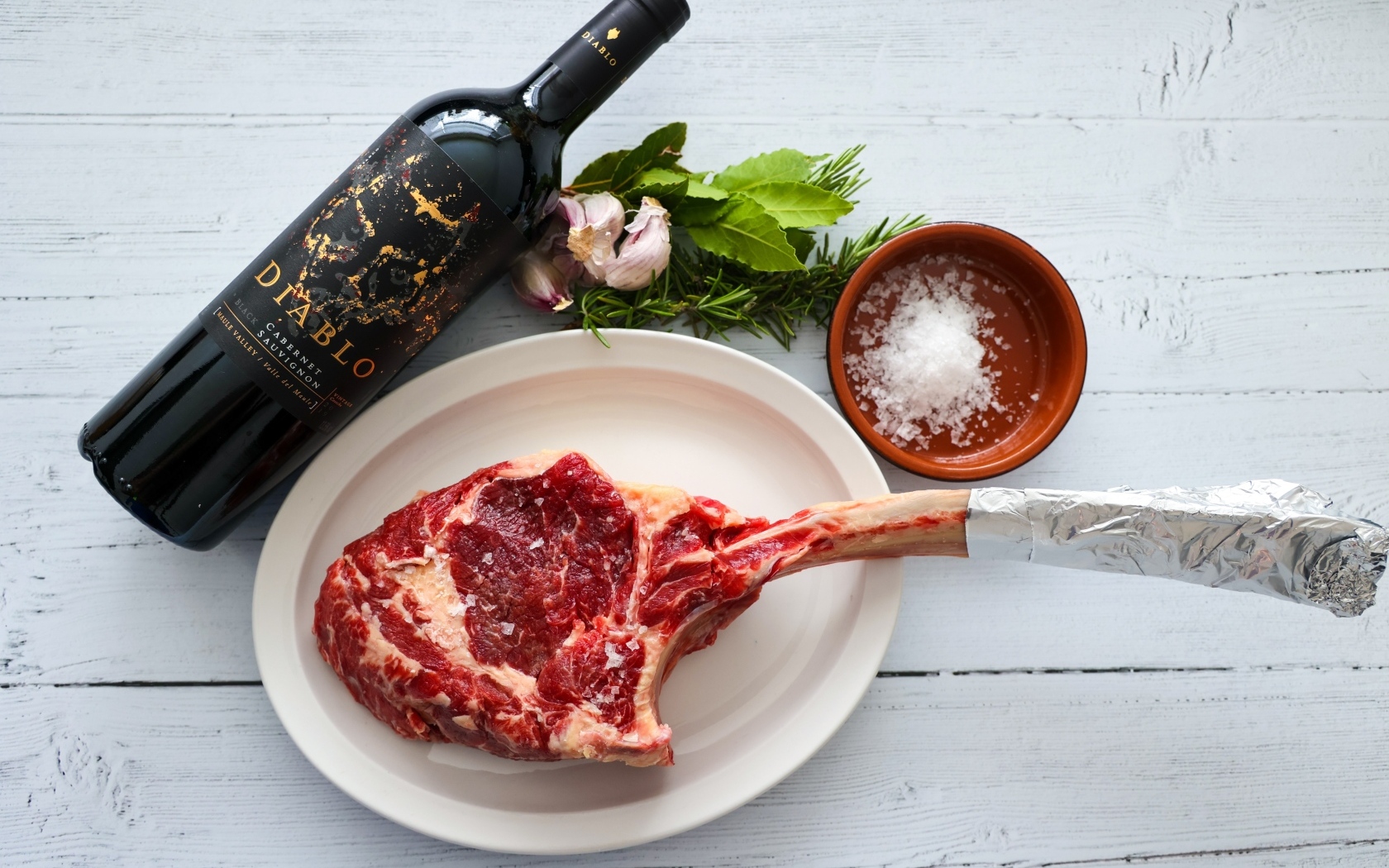 Стейк на кости с бутылкой вина