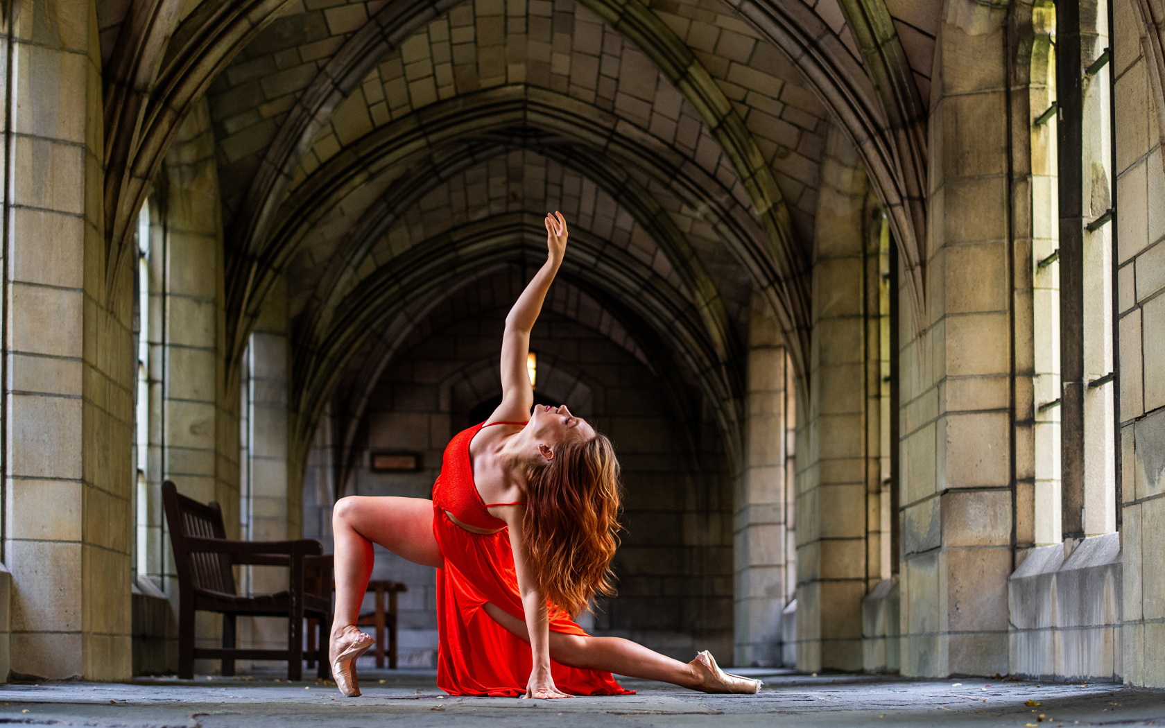 Девушка в красном наряде танцует в здании