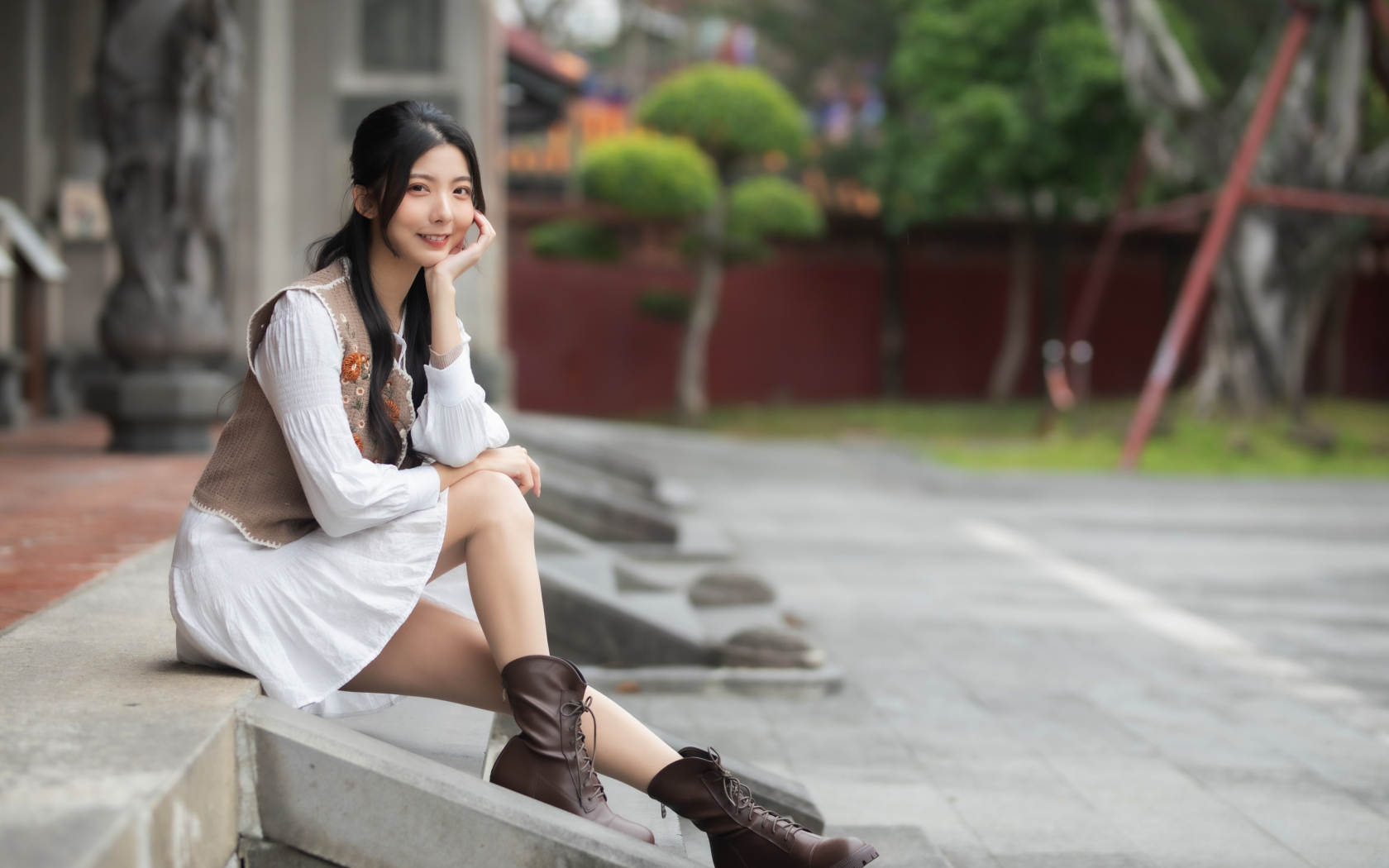 Азиатка сидит на холодных ступеньках