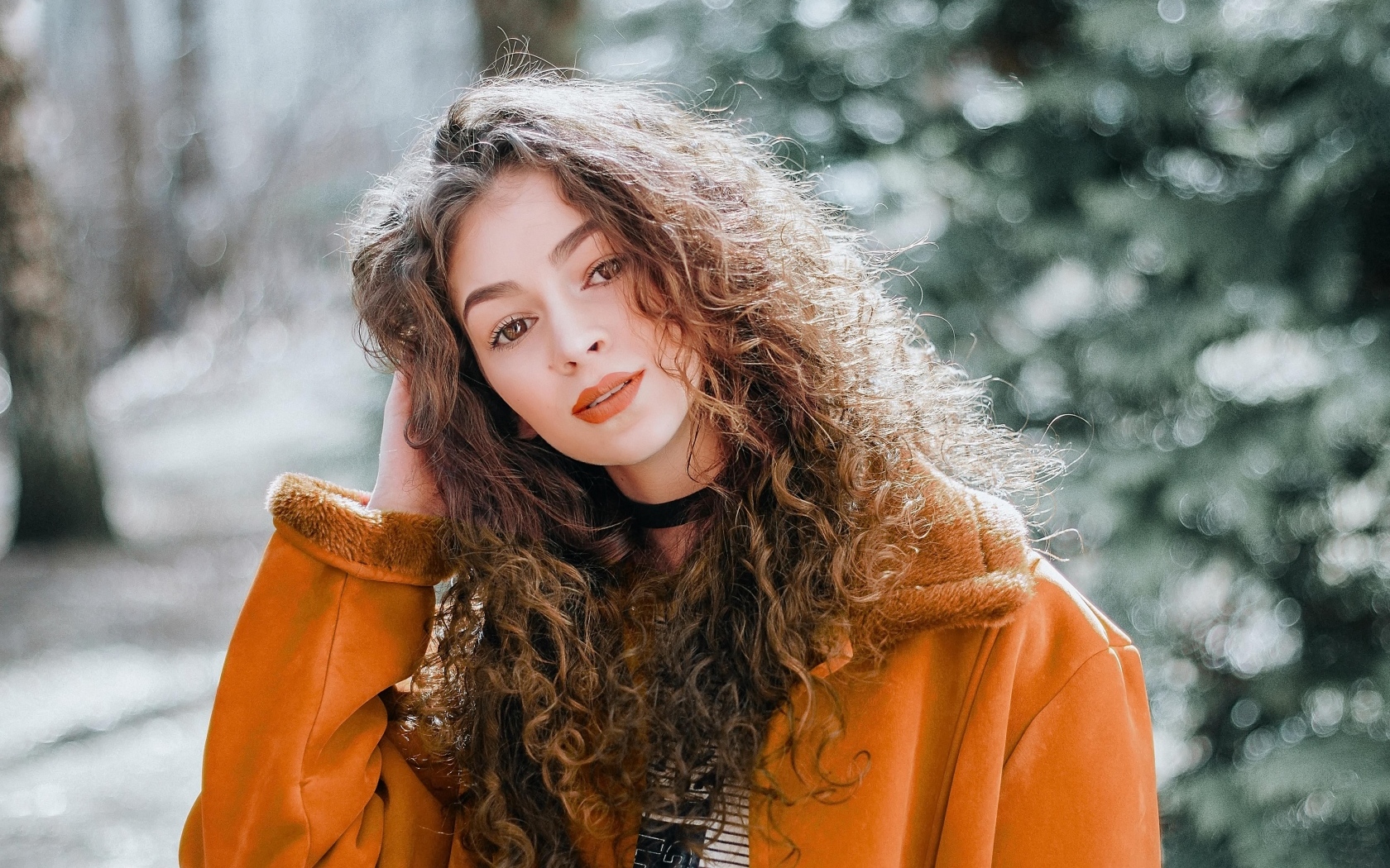 Красивая девушка с кудрявыми волосами и карими глазами