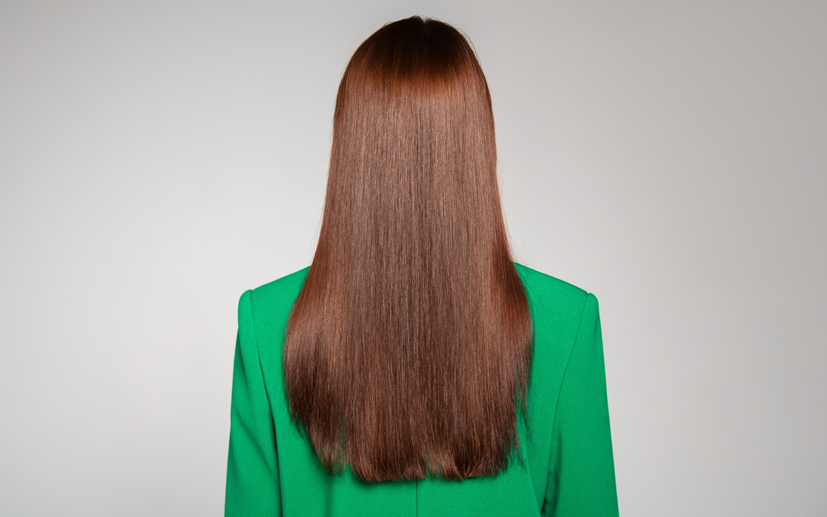 Красивые волосы девушки в зеленом пиджаке