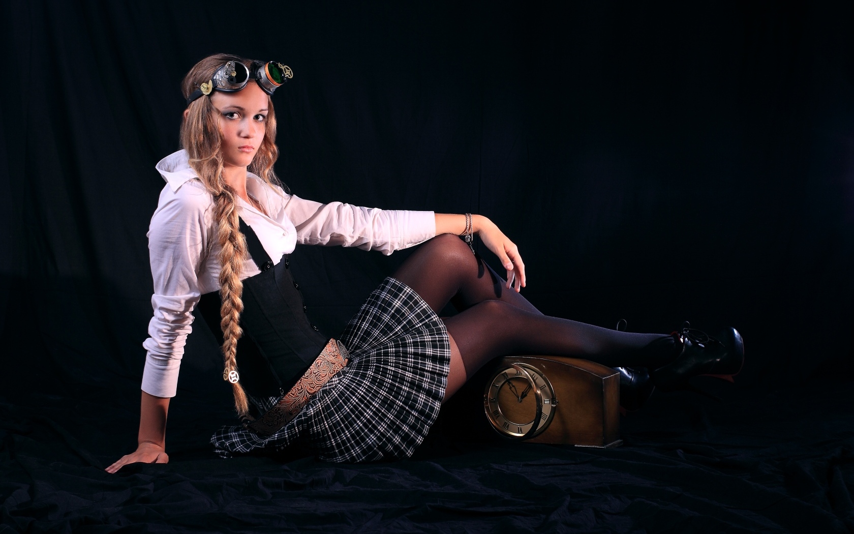 Девушка в костюме на черном фоне с часами