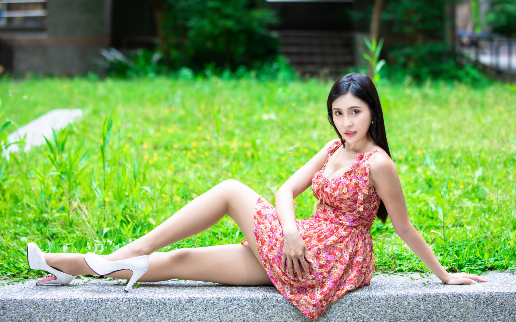 Длинноволосая азиатка в платье с белыми туфлями на ногах