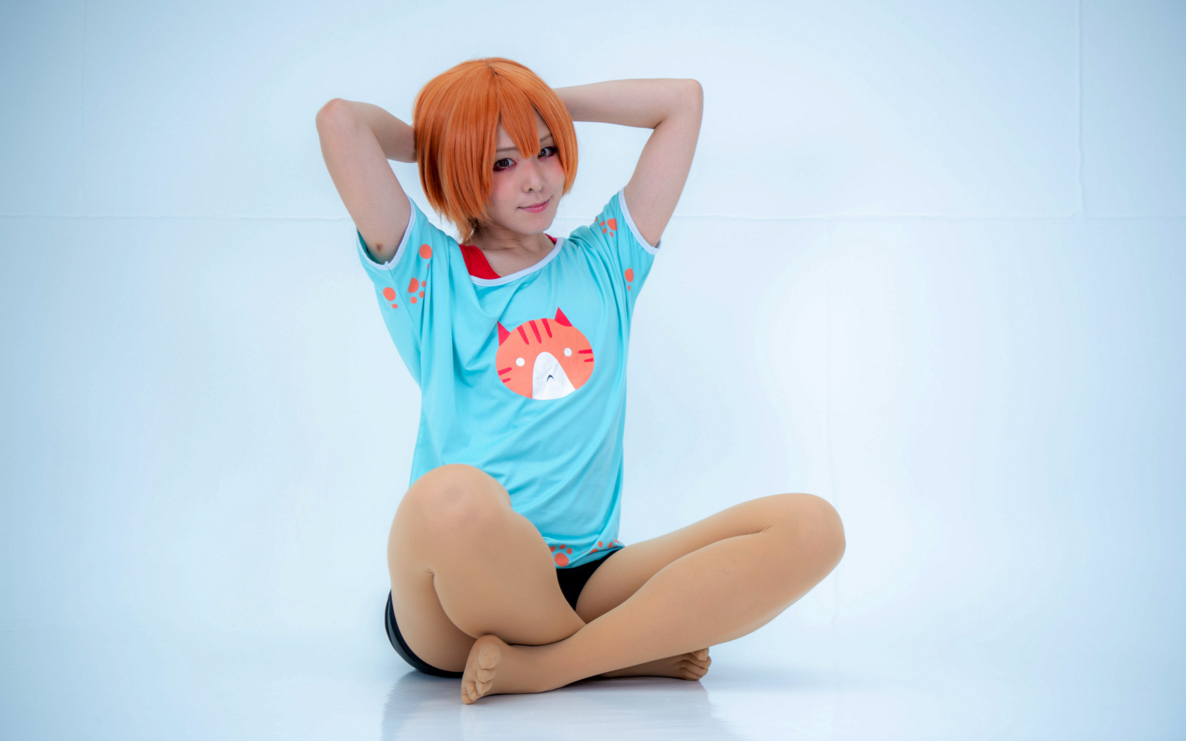 Рыжеволосая азиатка в милой футболке на голубом фоне