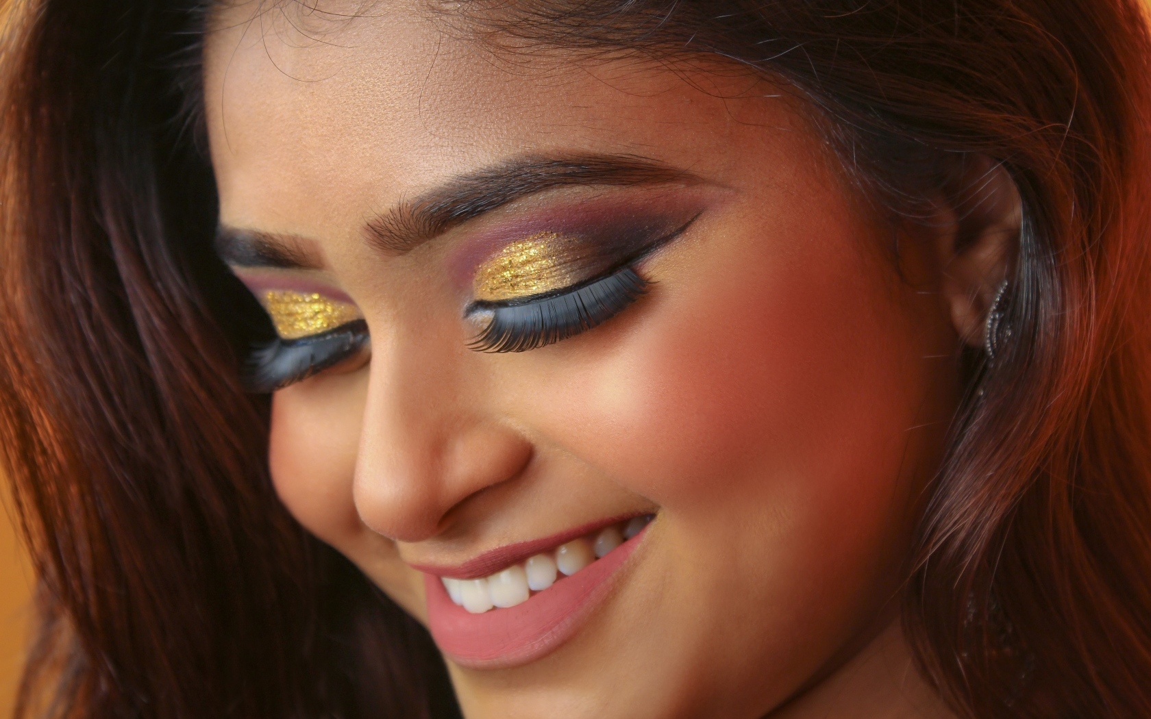 Улыбающаяся девушка с макияжем на глазах