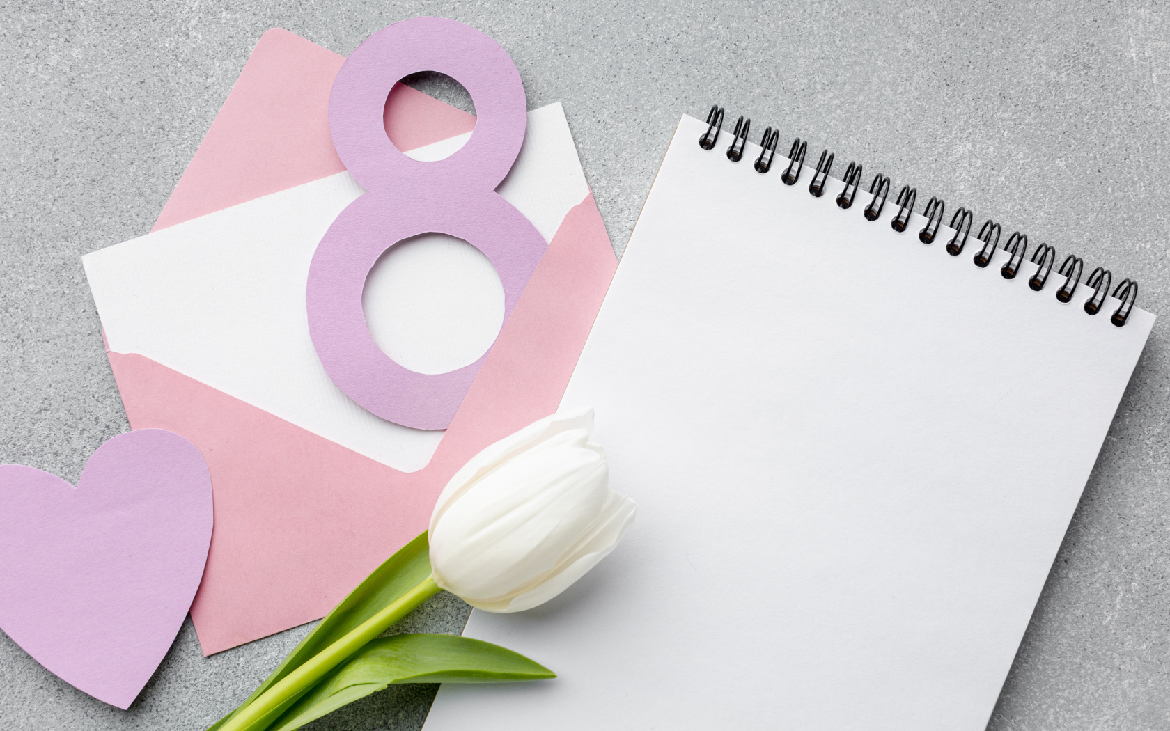 Конверт с блокнотом и белым тюльпаном на сером фоне на 8 марта