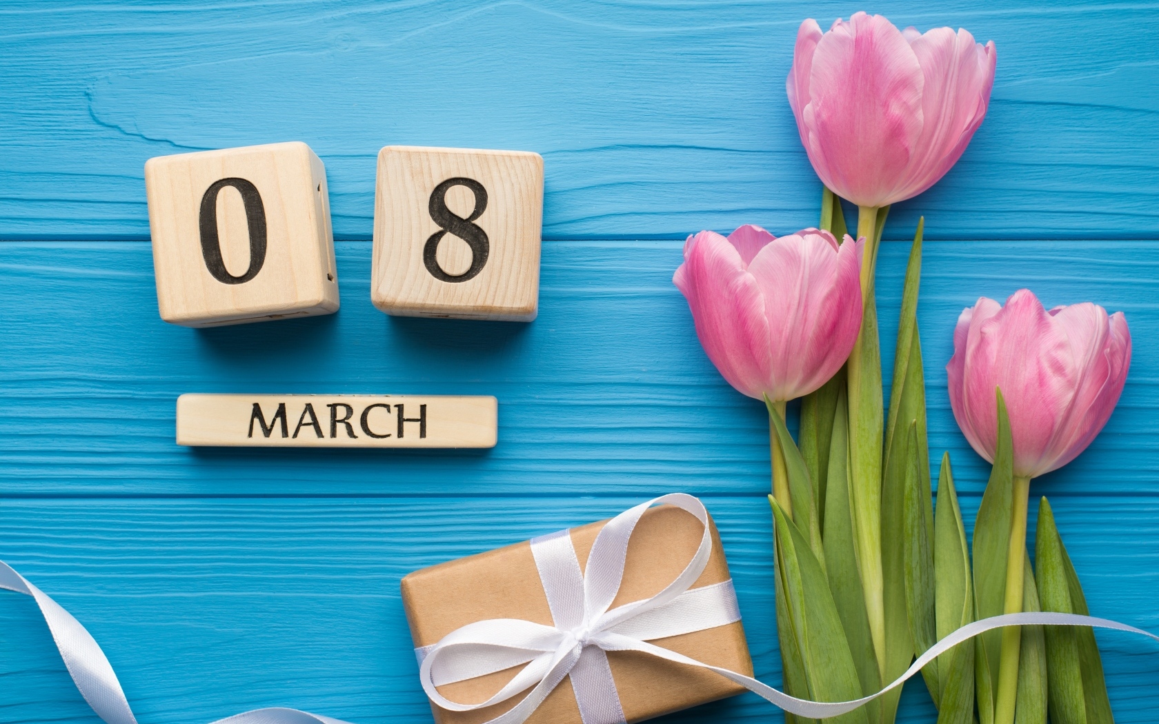 Розовые тюльпаны с подарком и кубиками на голубом фоне на 8 марта