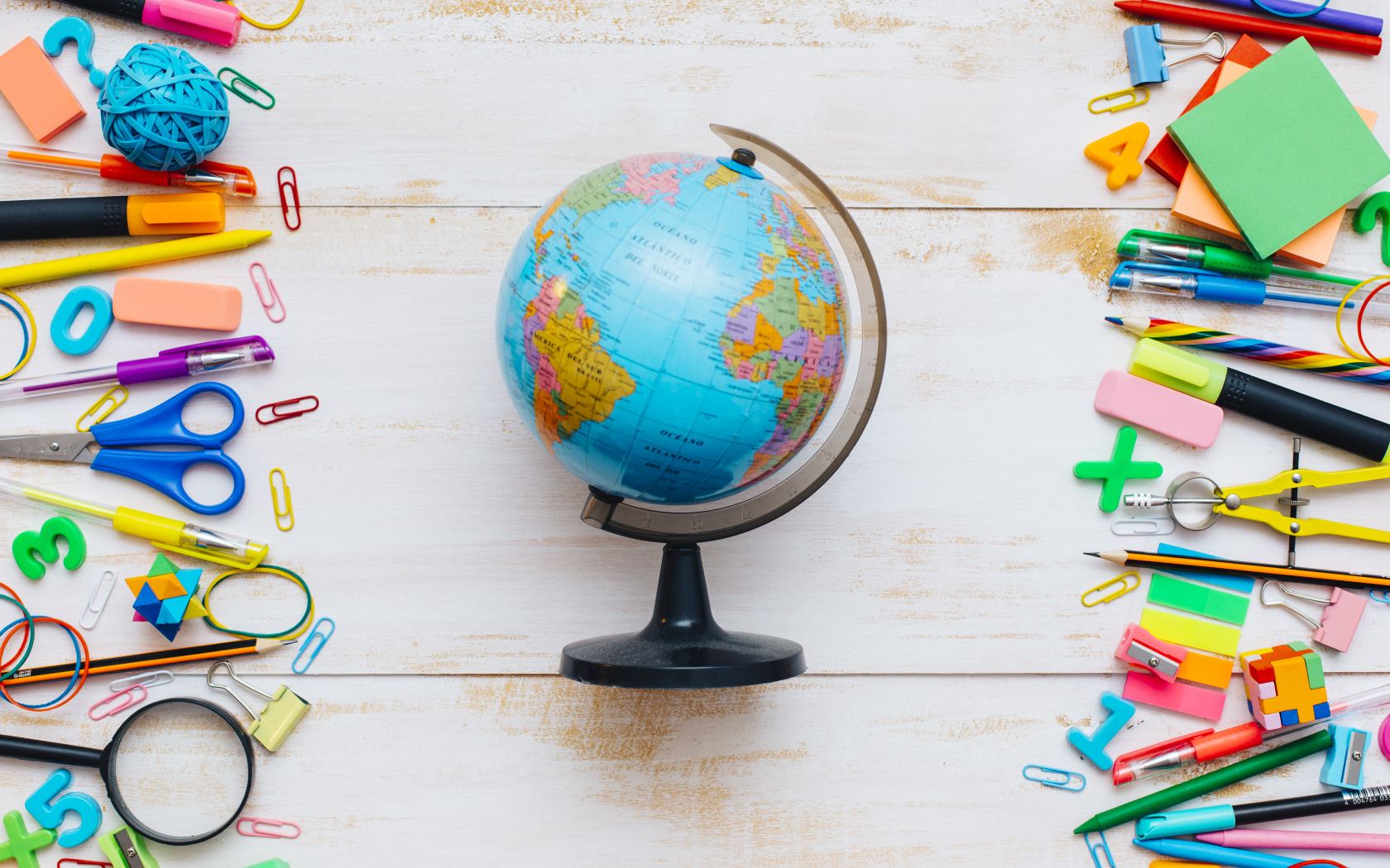 Глобус на деревянном фоне с канцелярскими предметами