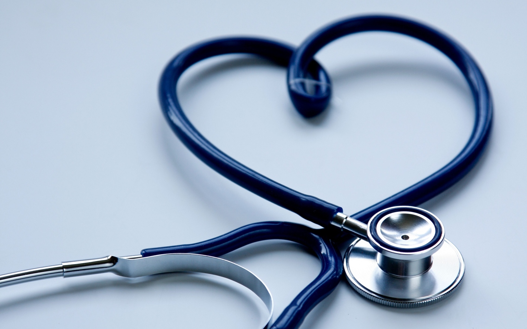 Сердце из стетоскопа на сером фоне